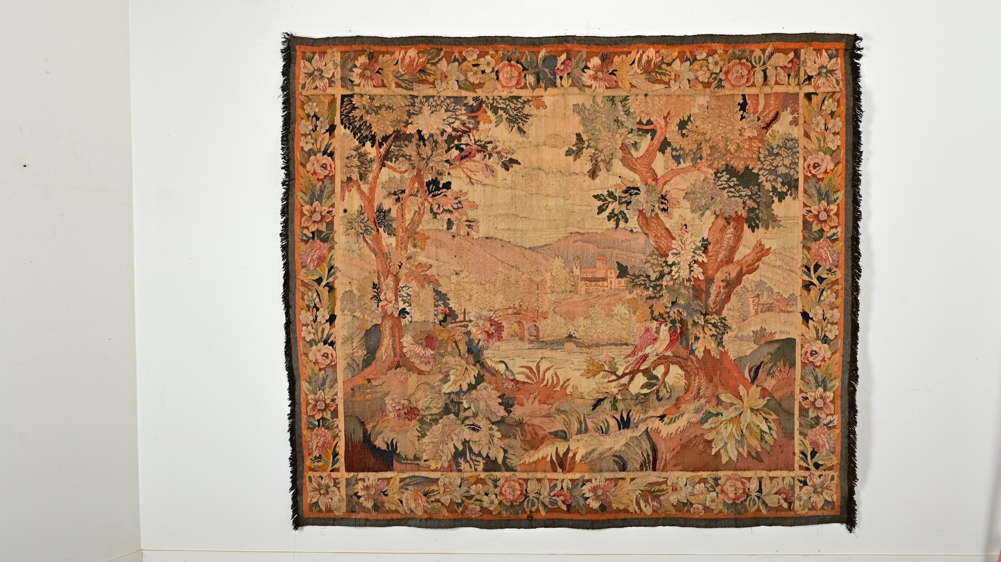 Questo romantico arazzo di verdure del XVIII secolo ti trasporterà in un'idilliaca cittadina rivierasca immersa nelle colline della campagna francese. Realizzato nei colori autunnali dell'arancio bruciato, dell'oro, del marrone, del rosso e del