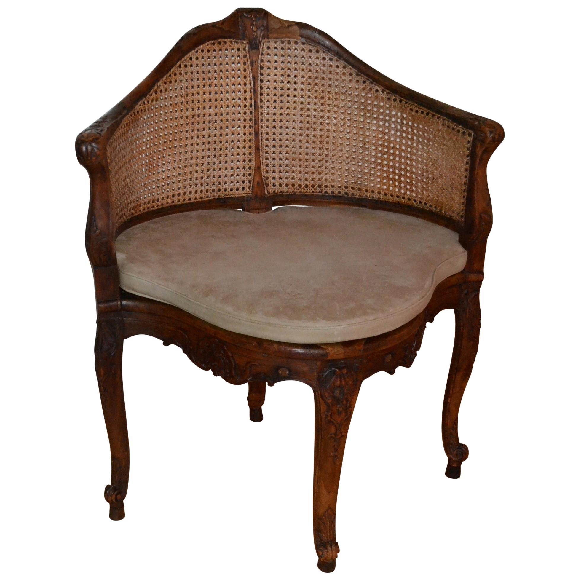 18th Century French walnut corner caned chair with a thin parchment colored leather pillow.
  