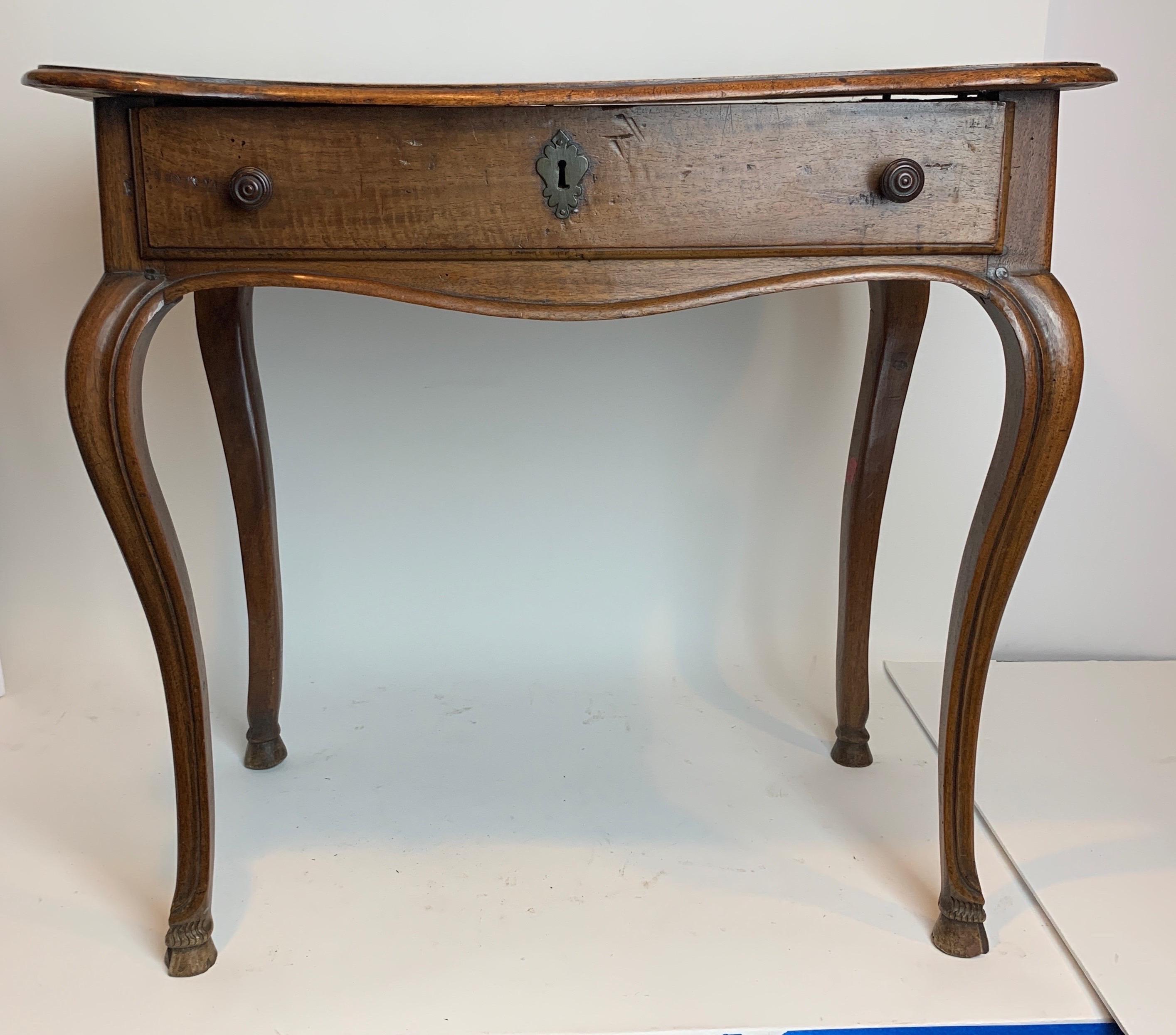 French work table with cabriole legs and a hoof foot. 18th century and made out of Walnut. One drawer on front. Single board top with a thumb molding. Distressed top.