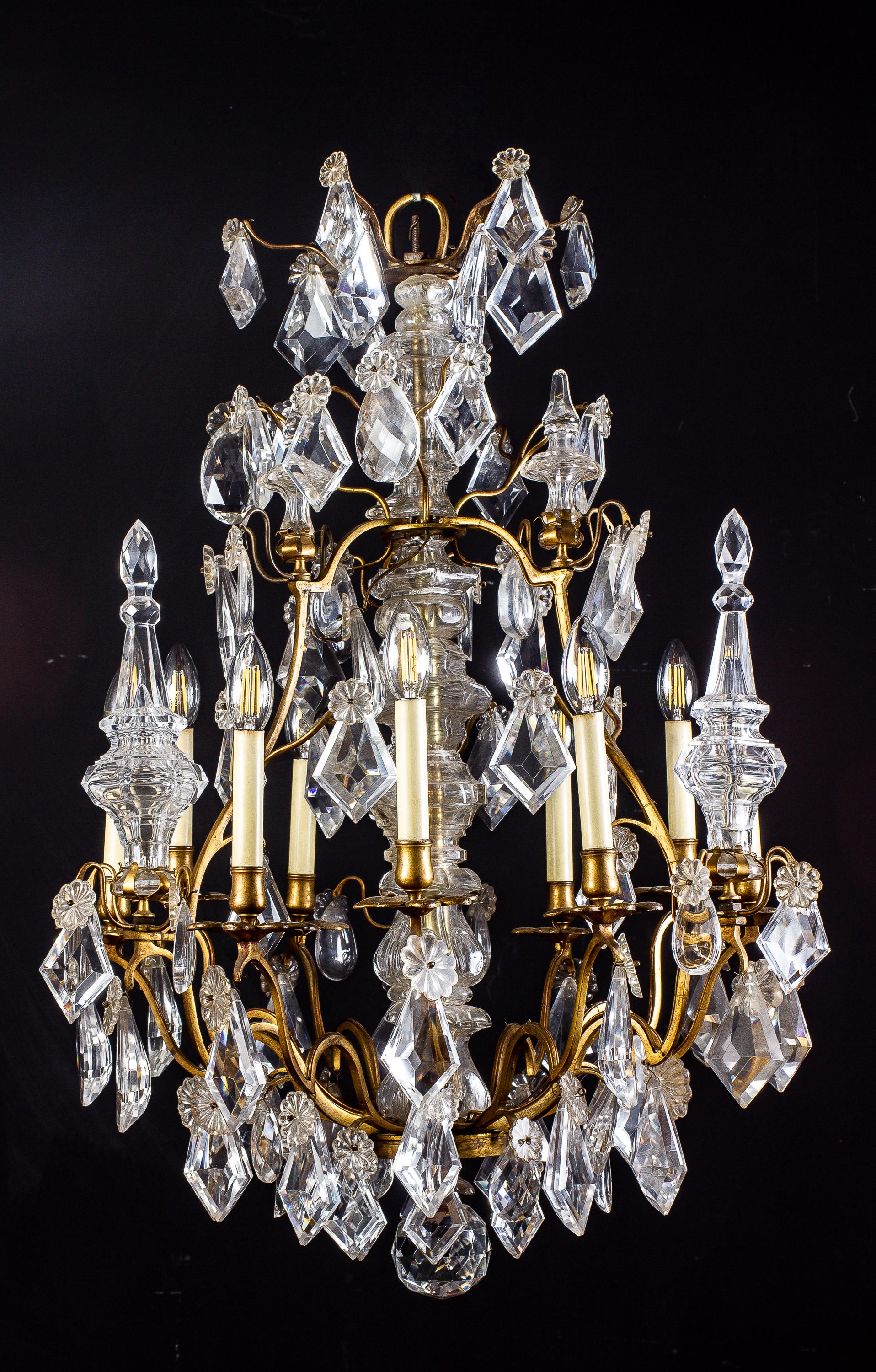 This elegant and stunning chandelier of cartouche outline, with crystal faceted drops, rosettes obelisks all from crystal, terminating with a faceted solid crystal ball. Professionally rewired for electricity 9 lights.