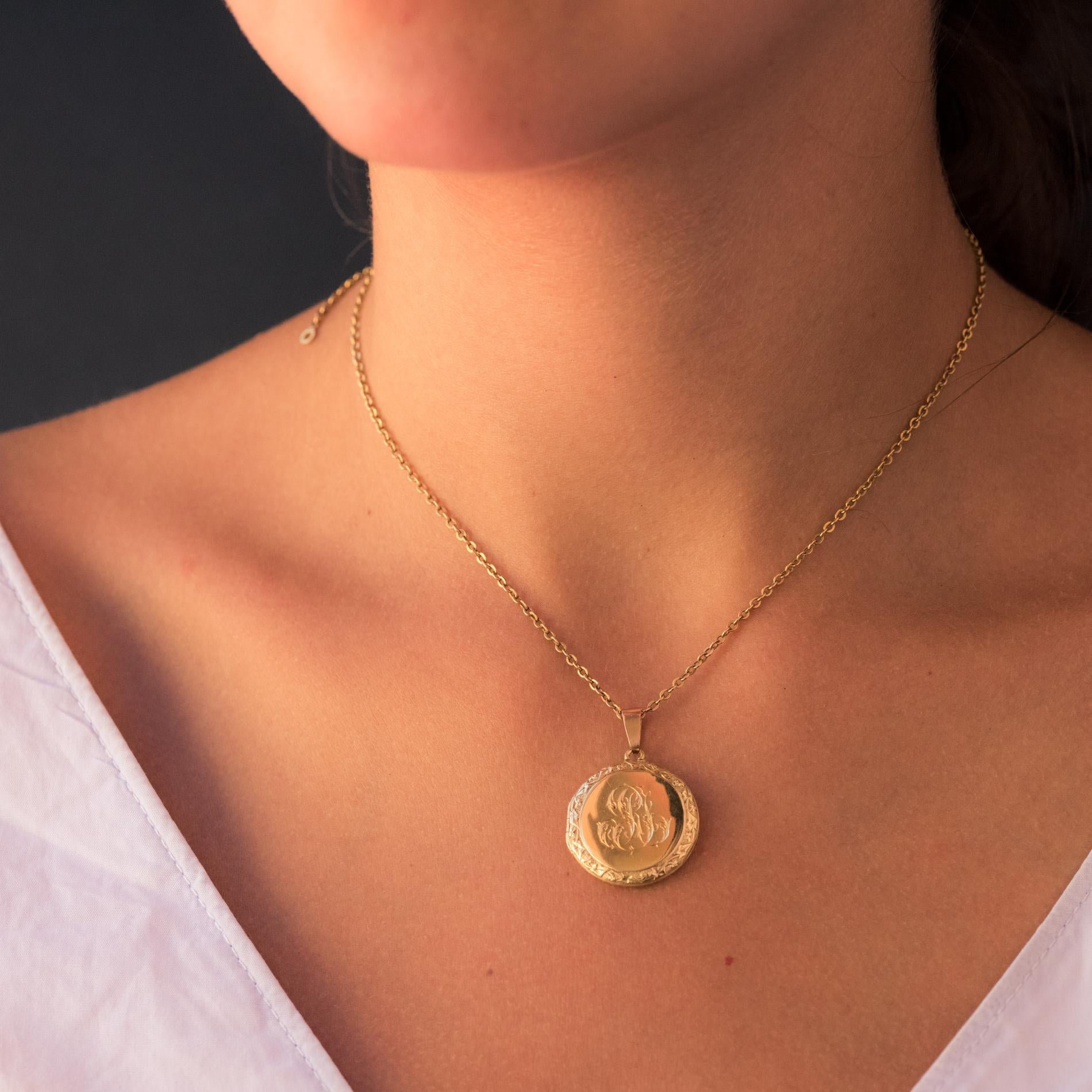 Pendant in 18 karat yellow gold, eagle's head hallmark.
Round in shape, this charming antique jewel of charm is engraved on its front face with a wreath of ivy leaves and in the center of initials. Its rear face is smooth. It opens with a small