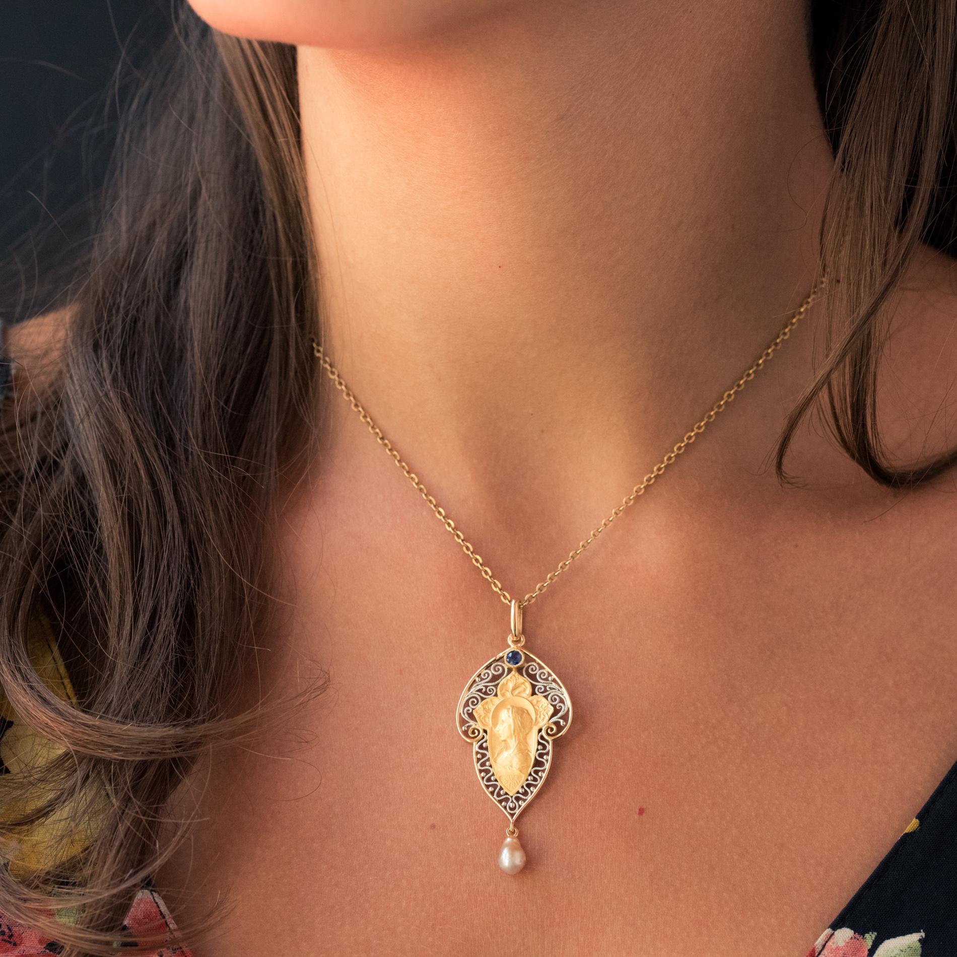 Pendant in 18 karat yellow and white gold eagle's head hallmark.
Superb antique jewel it is composed of an openwork decoration of arabesques in white gold filigree which hold in the center a medal in mat gold representing the haloed virgin. 