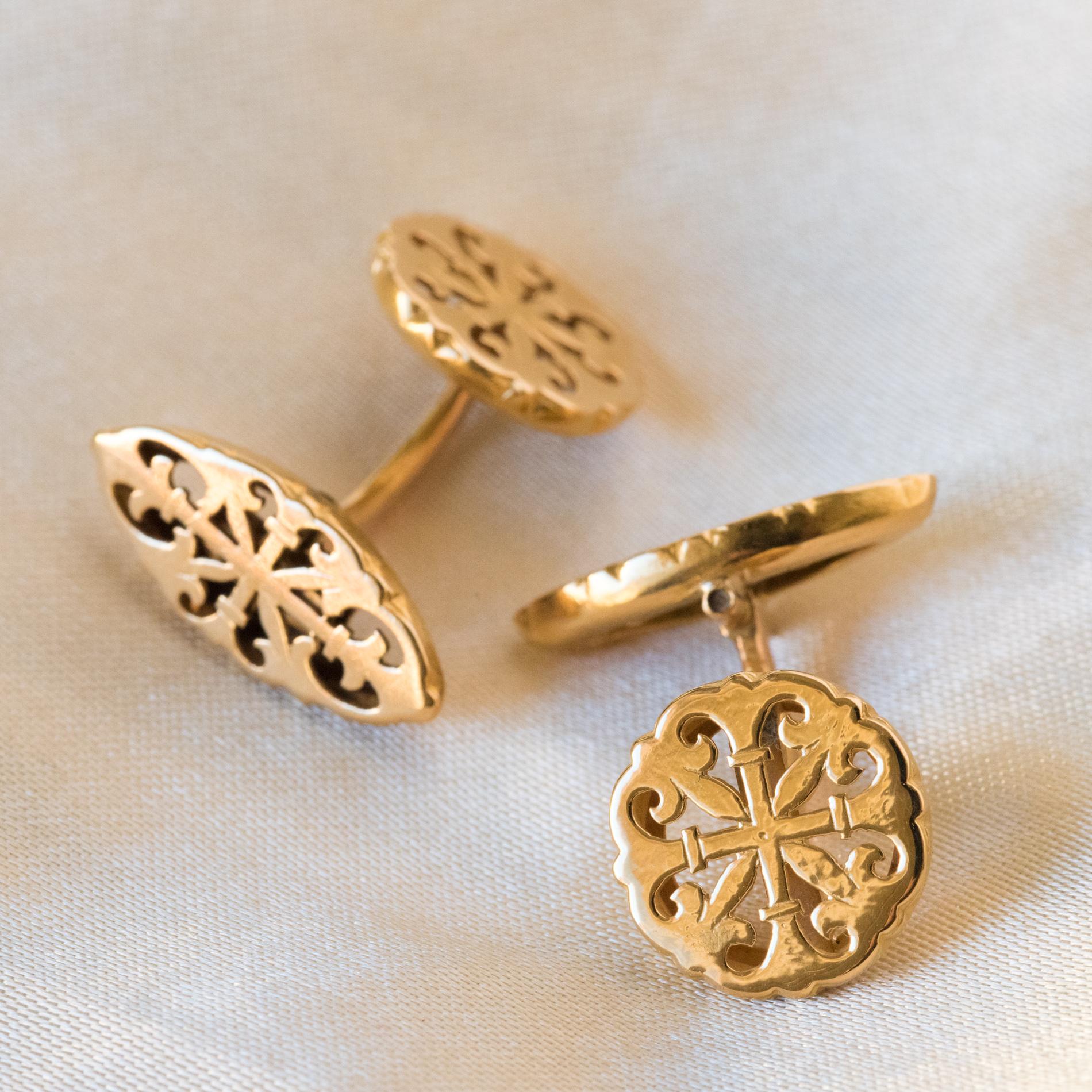 Cufflinks in 18 carats yellow gold, eagle's head hallmark.
Round shape, each cufflink is openworked with fleur-de-lis pattern. The catch is shuttle-shaped, and takes the same scenery.
Diameter: 13 mm, thickness: 2.8 mm.
Length of the shuttle