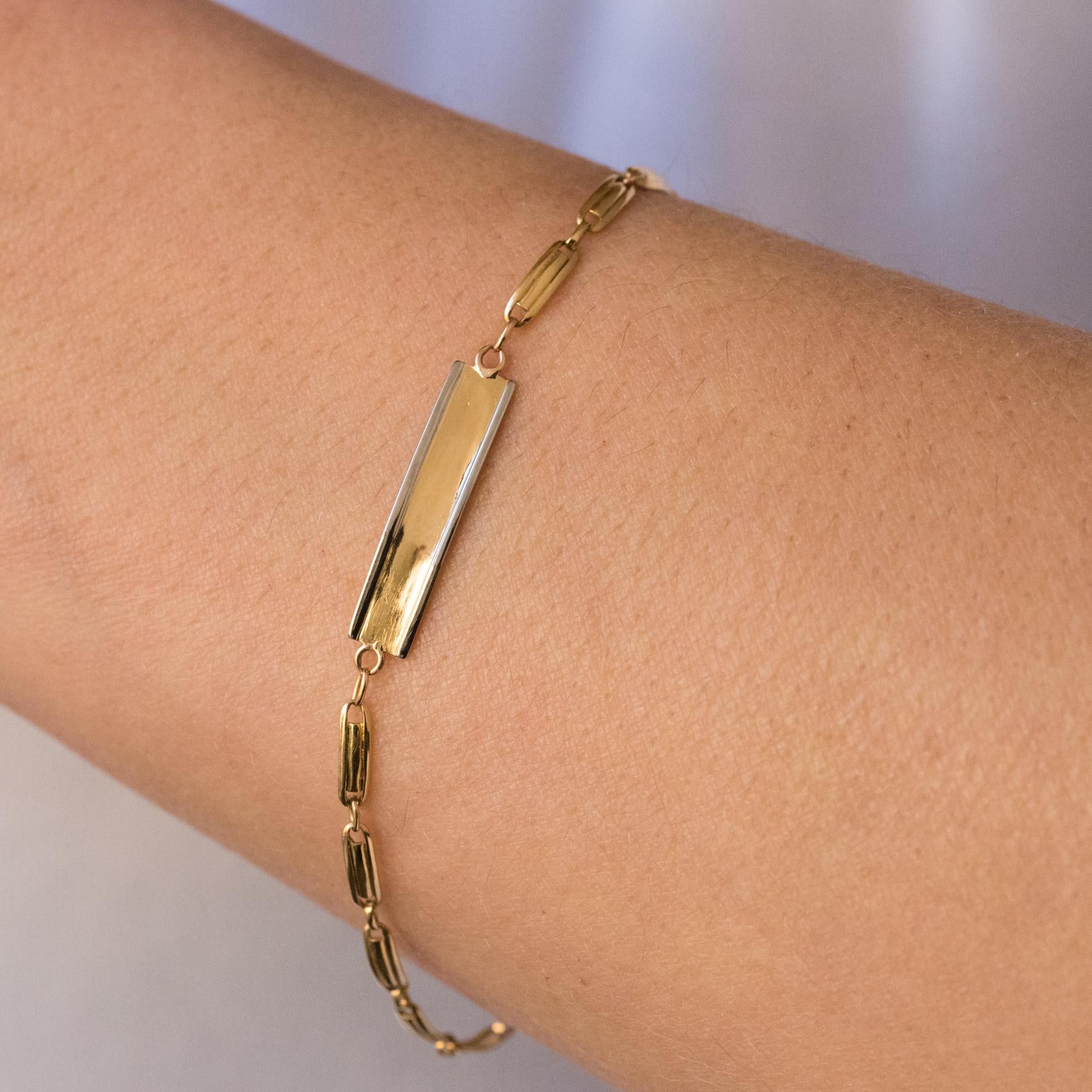 Bracelet in 18 karats yellow gold, eagle's head hallmark.
Lovely little antique bracelet, it is formed of a mesh made of gold staples holding a small yellow gold plate edged with white gold. The clasp is a spring ring.
Total length: 17 cm, width: