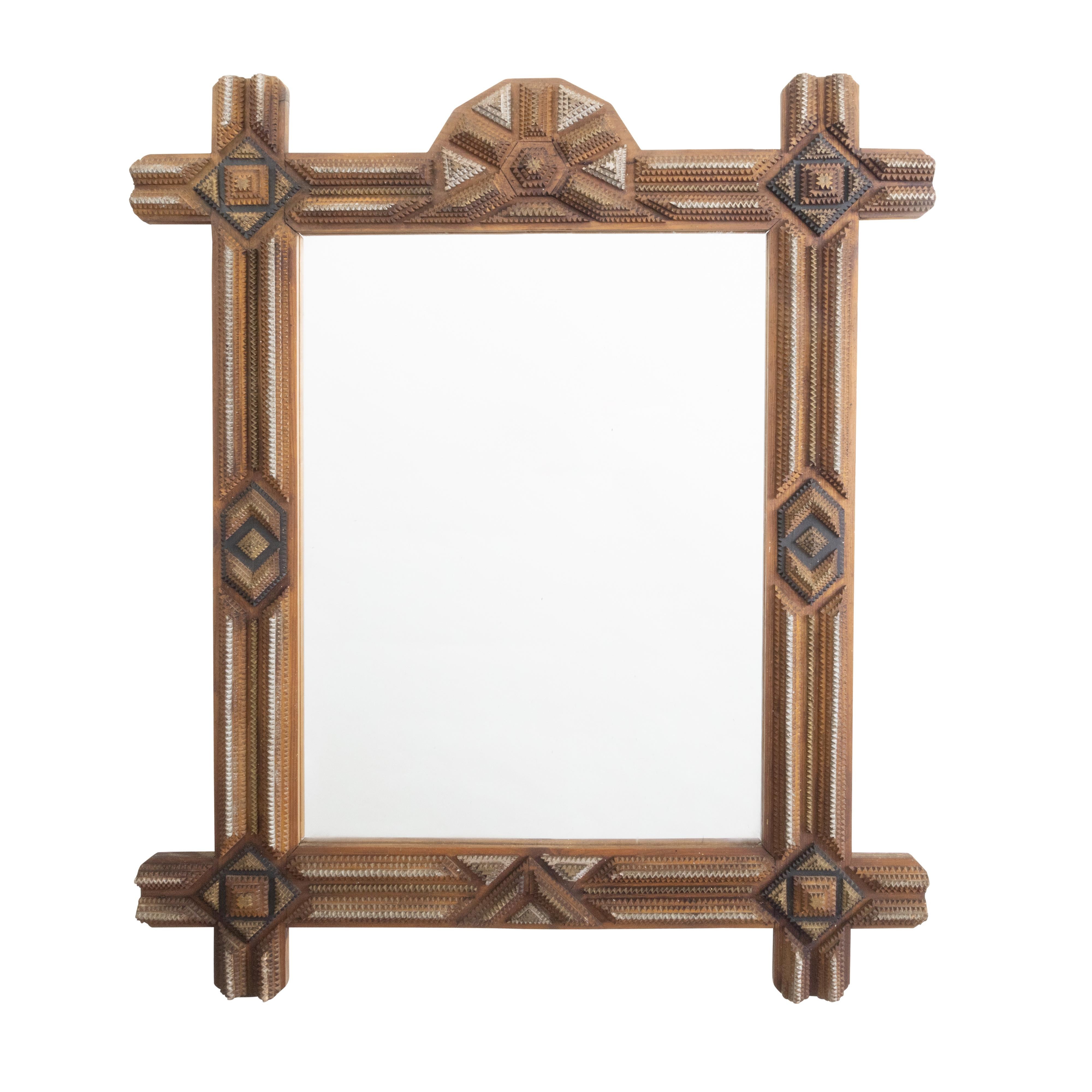 A French Tramp Art hand-carved mirror from the early 20th century with geometric motifs and painted accents. Created in France during the turn of the century, this mirror was hand carved in the manner typical of the Tramp Art style. Consisting of a