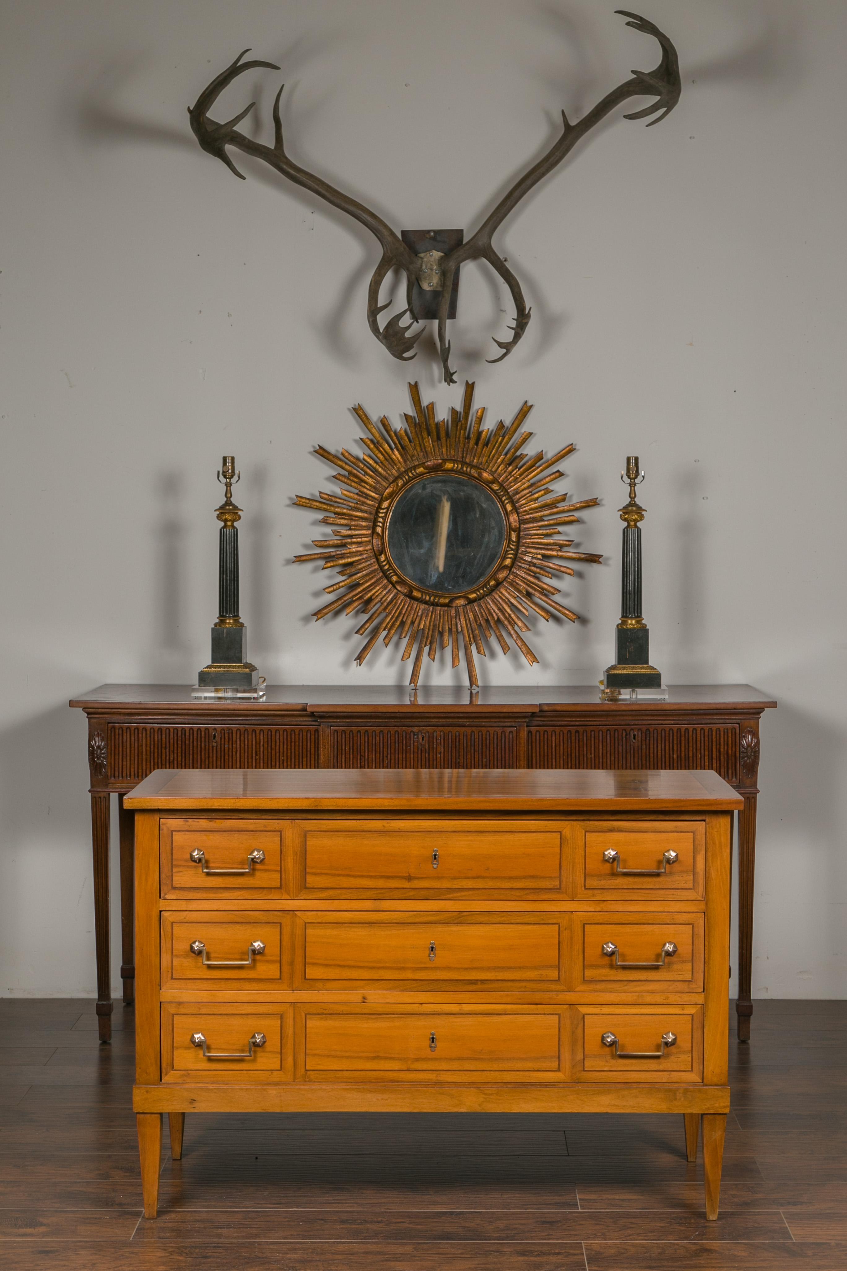 A French Directoire style walnut commode from the early 20th century, with three drawers, banding and tapered legs. Born in France during the early years of the 20th century, this Directoire style commode features a rectangular top sitting above