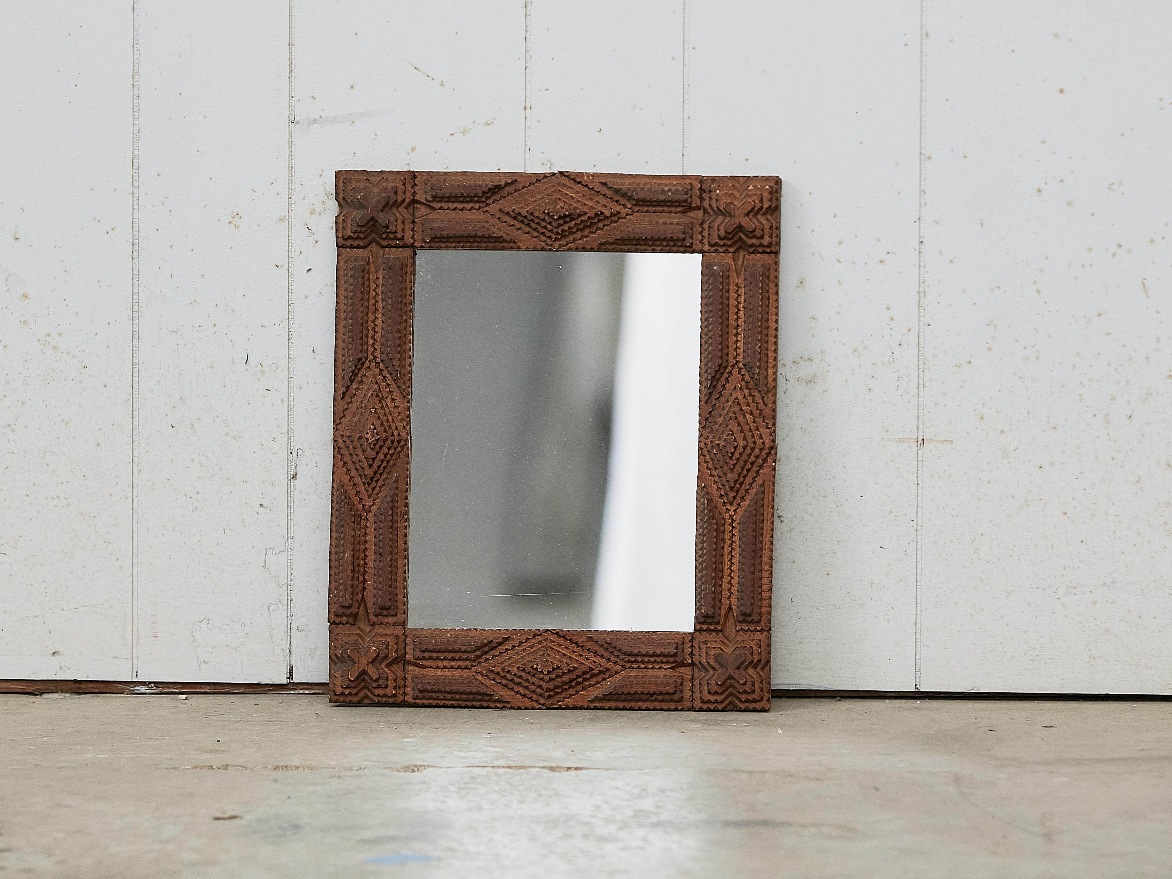 A French rectangular Tramp Art hand carved wooden mirror from the early 20th century, with raised diamond motifs and X patterns. Created in France during the Turn of the Century which saw the transition between the 19th to the 20th, this wall mirror