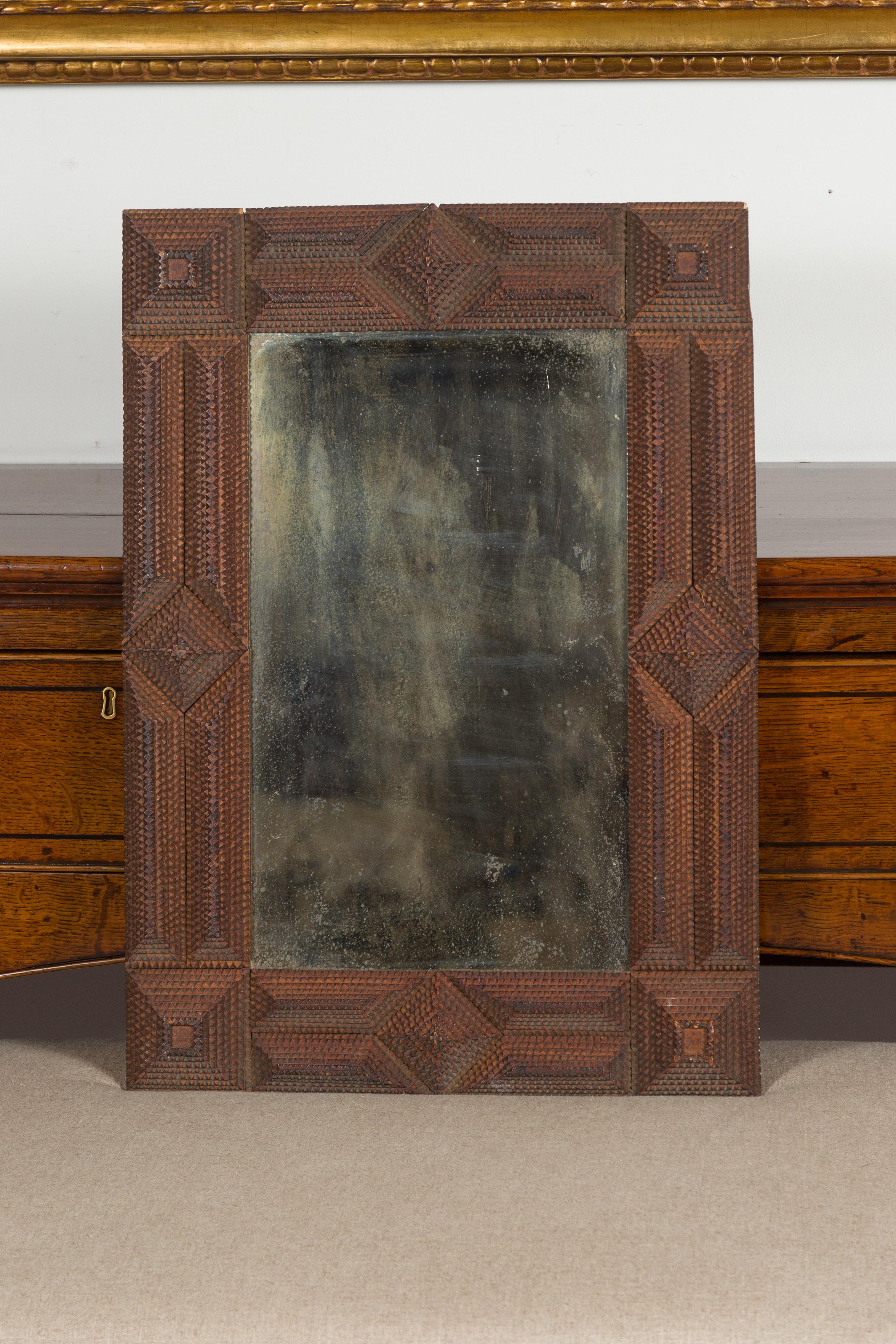 A French Tramp Art hand carved mirror from the early 20th century with raised pyramidal motifs. Created in France during the turn of the century, this rectangular mirror was hand carved in the manner typical of the Tramp Art style. Consisting of a