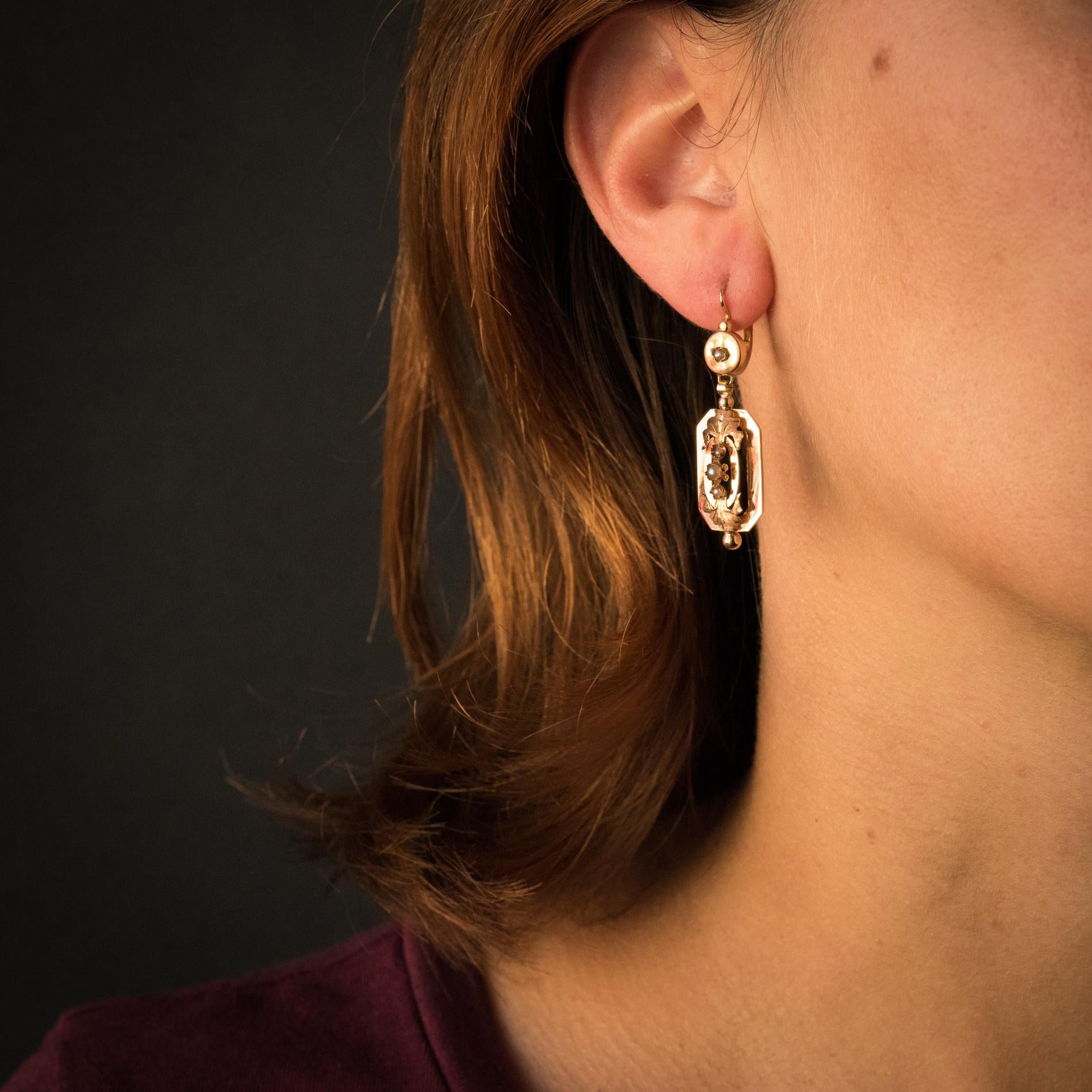 Earrings in 18 karats rose gold, horse's head hallmark.
A disc, set with a natural pearl, composes the sleeper part of these antique earrings. It holds a rectangular motif in pendants with an oval motif adorned with chiseled leaves and adorned with