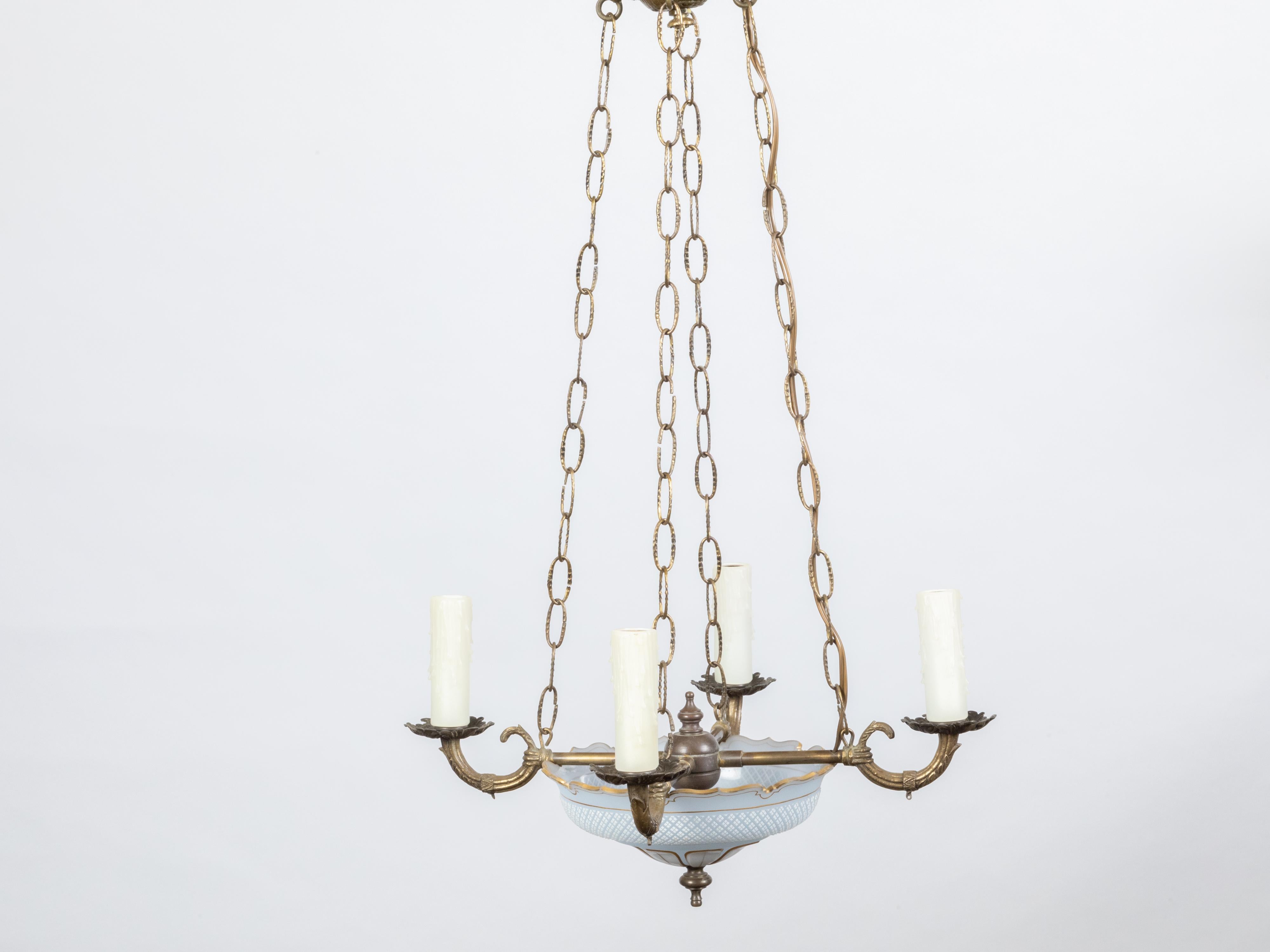 A French opaline chandelier from the early 20th century, with four lights and profiled links. Created in France at the Turn of the Century, this chandelier features an opaline basket with cross hatched patterns and leaf motifs, delicately