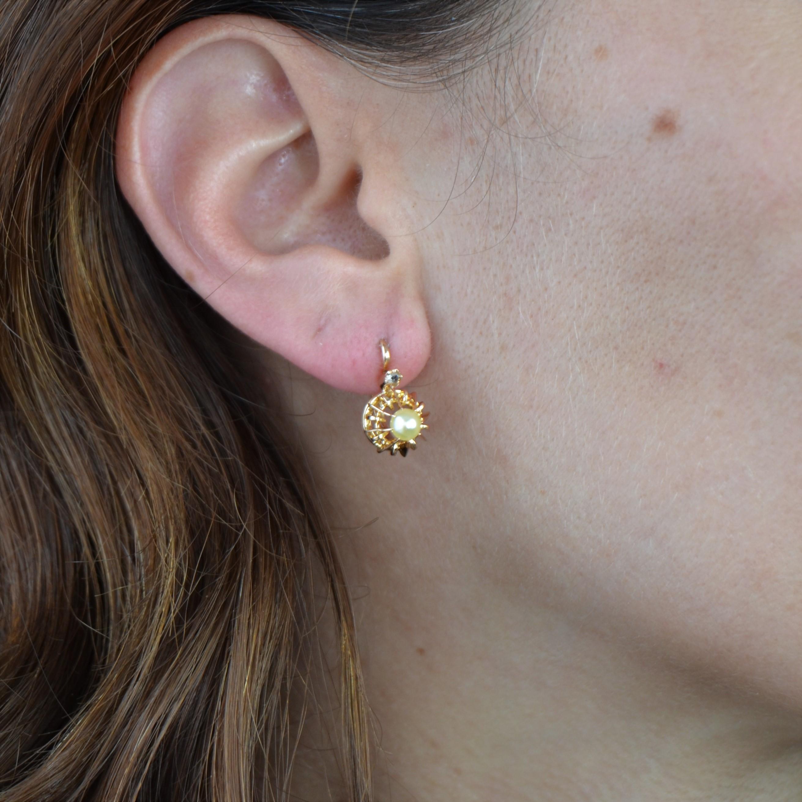 For pierced ears.
Pair of earrings in 18 karat rose gold, horse head hallmark.
Charming lever- back earrings, they are decorated in the center of a decoration made of openwork gold blades, a pearl button topped by a small rose-cut diamond, dahlia
