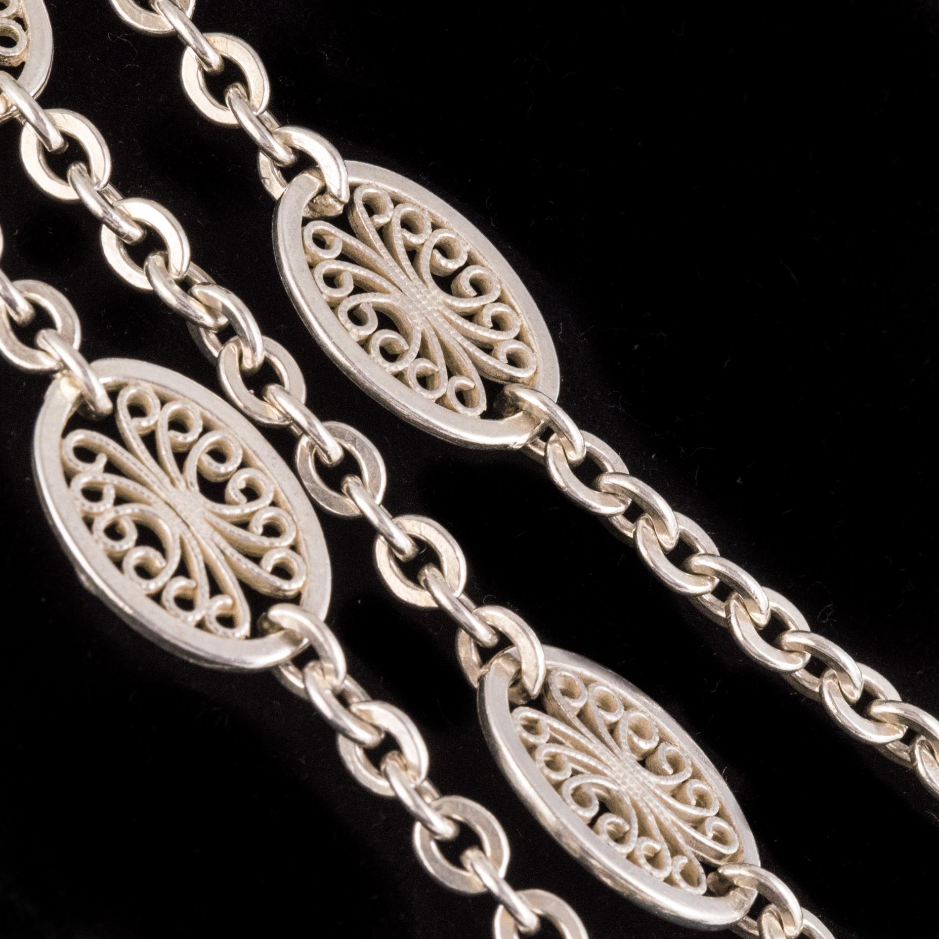 Long necklace in silver, crab hallmark.
This magnificent antique long necklace is made up of an oval cable mesh separated by an oval pattern with openwork filigree. The clasp is a spring ring.
Total length : approximately 140 cm, width at the level