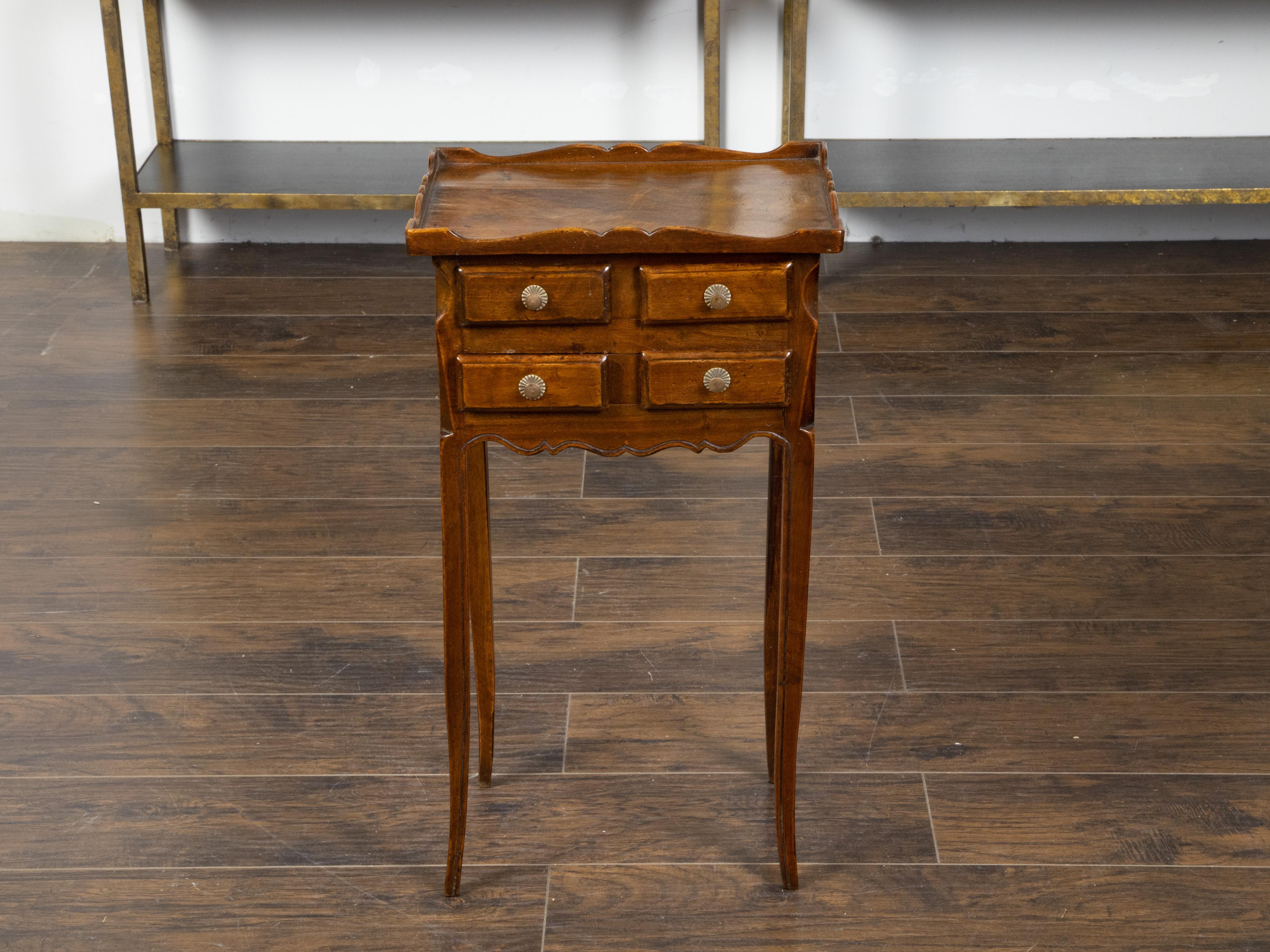 A French walnut side table from the early 20th century, with carved tray top and four small drawers. Created in France during the Turn of the Century, this walnut side table features a rectangular carved tray top sitting above four small drawers