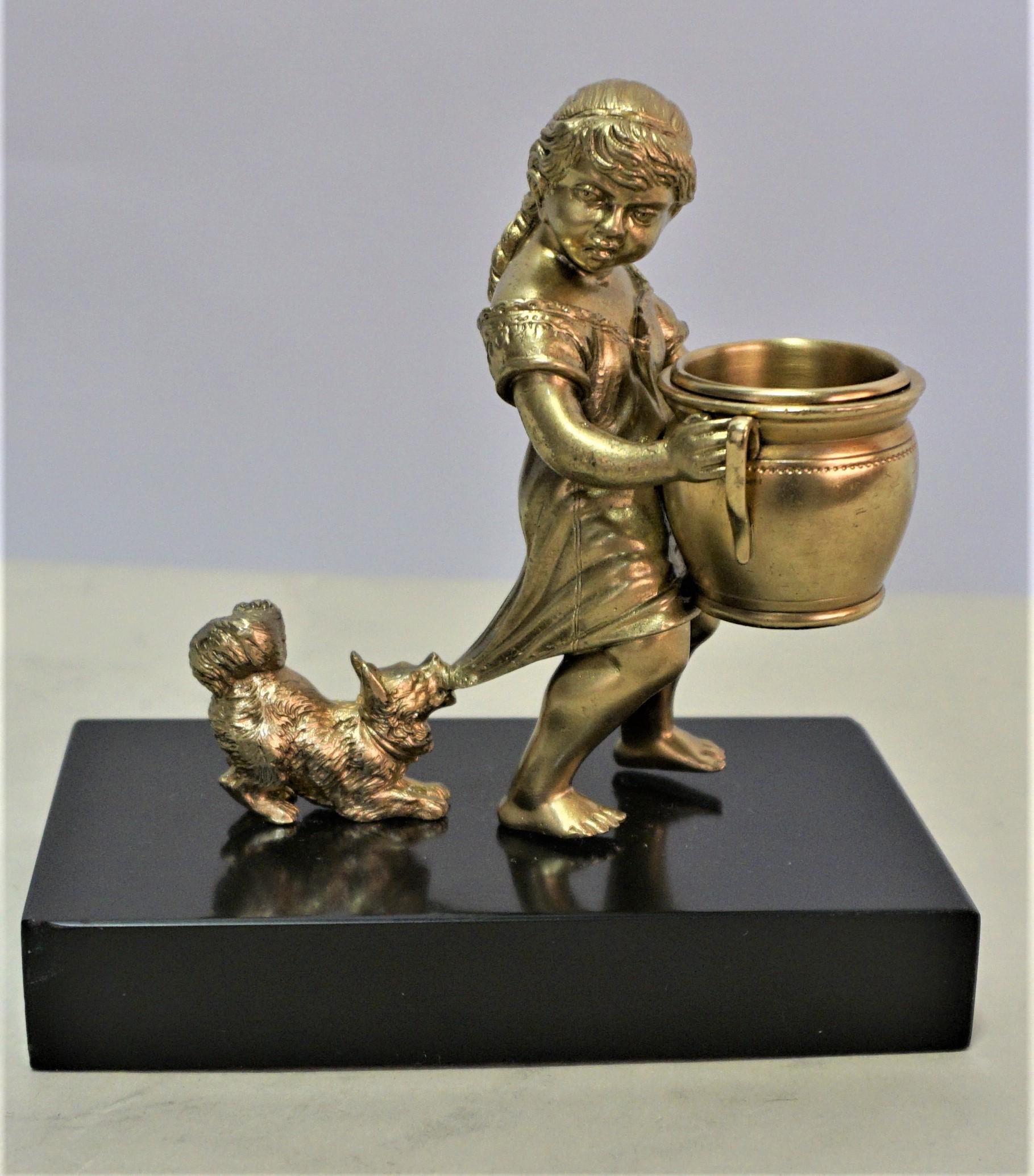 Adorable bronze statue of a young little girl pulled by the dog.
