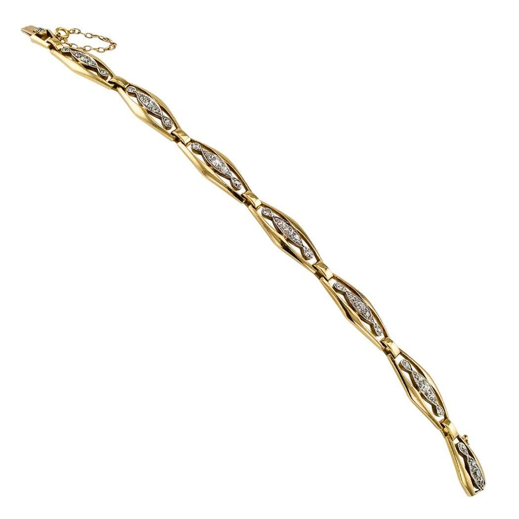 Edwardian 1910 French diamond gold and platinum link bracelet. The open work design comprises a series of 18-karat yellow gold, navette-shaped links, each link decorated in the center by an elongated platinum topped motif set with round diamonds,