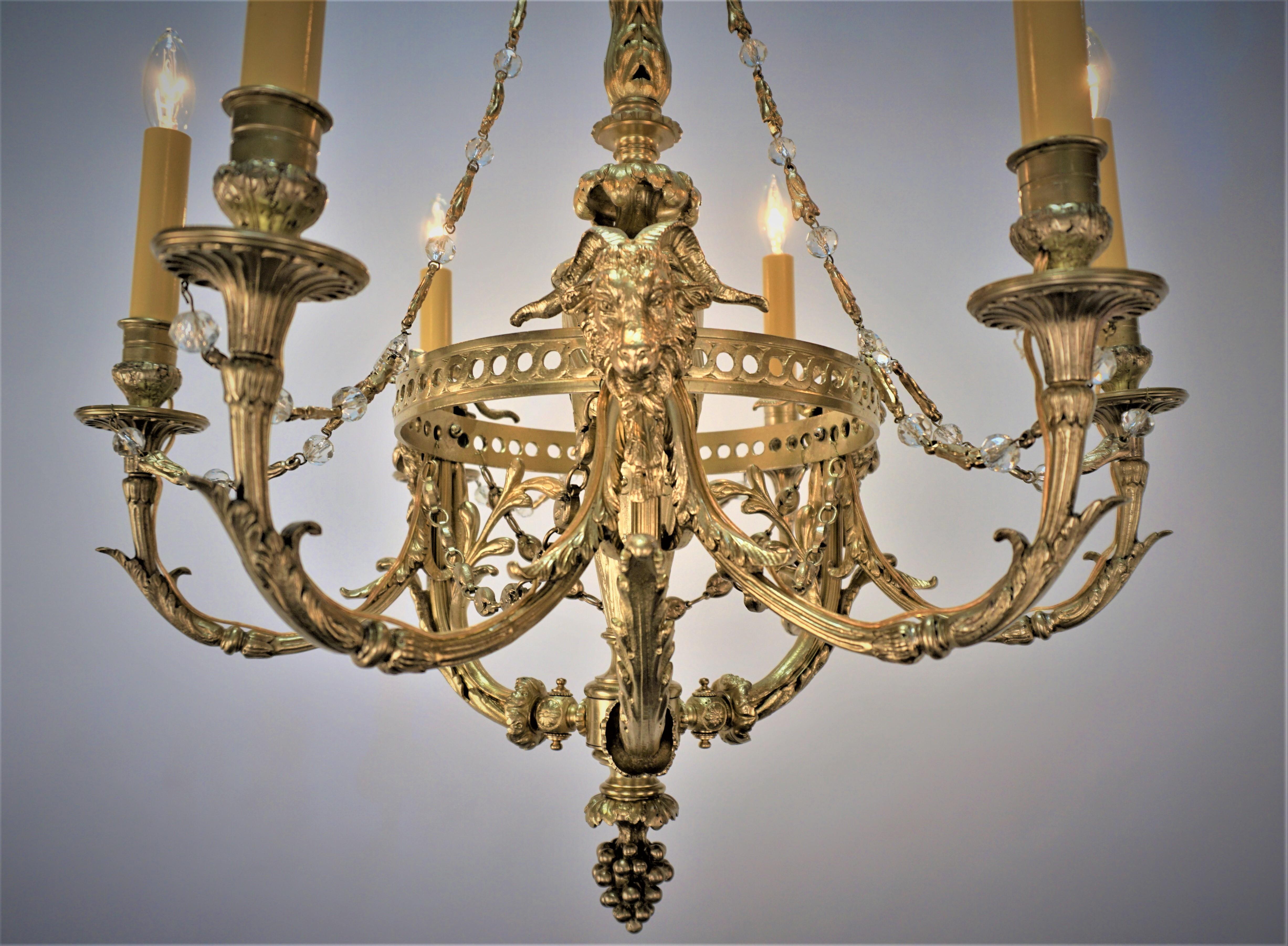 Crafted in France during 1900 elegant bronze work with ram heads and few accent crystal empire chandelier.