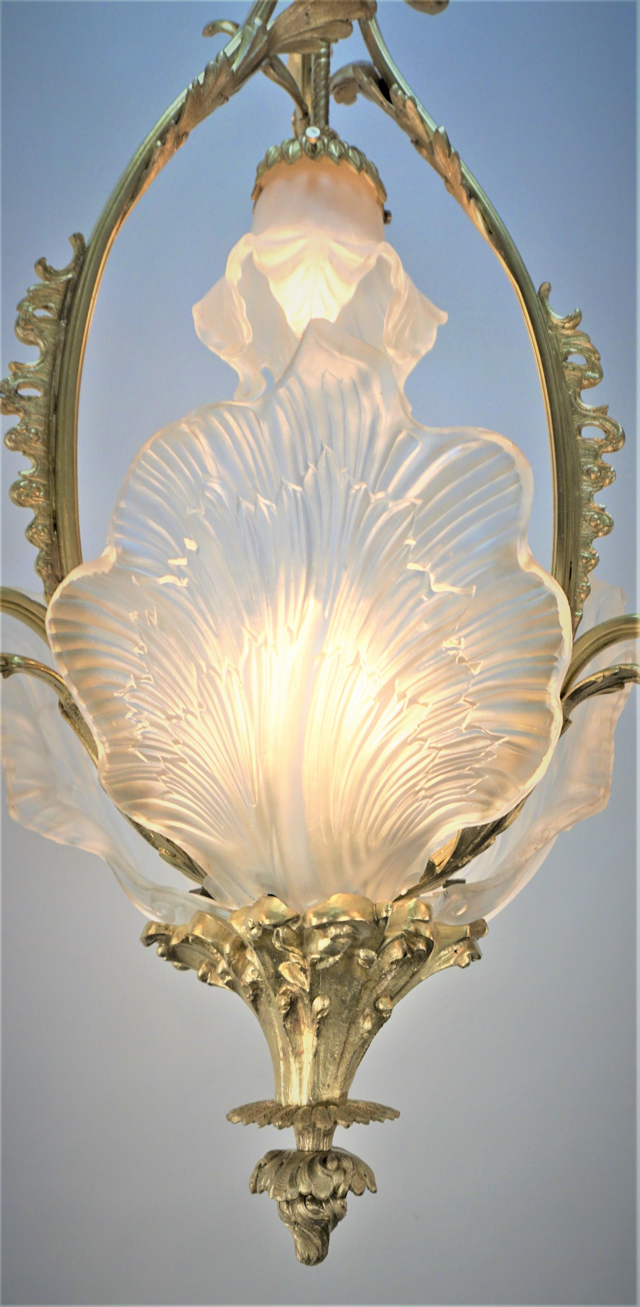 Elegant bronze chandelier with hand blown glass flora design and three panel molded leaf center shades.
