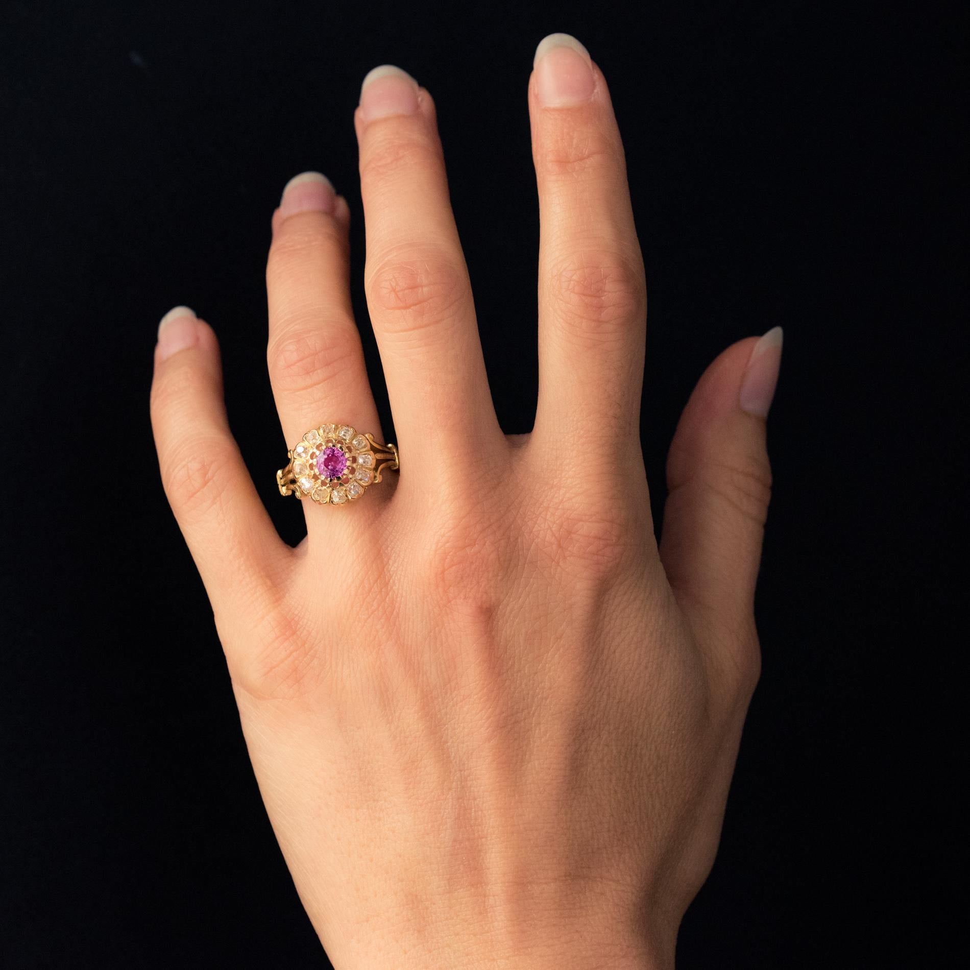 Ring in 18 karat yellow gold, horse's head hallmark.
Round shaped, this daisy ring is claw-set with a pink sapphire, surrounded by antique cushion-cut diamonds. On either side, the start of the ring forms an openwork fleur-de-lis.
Height : 13.8 mm,
