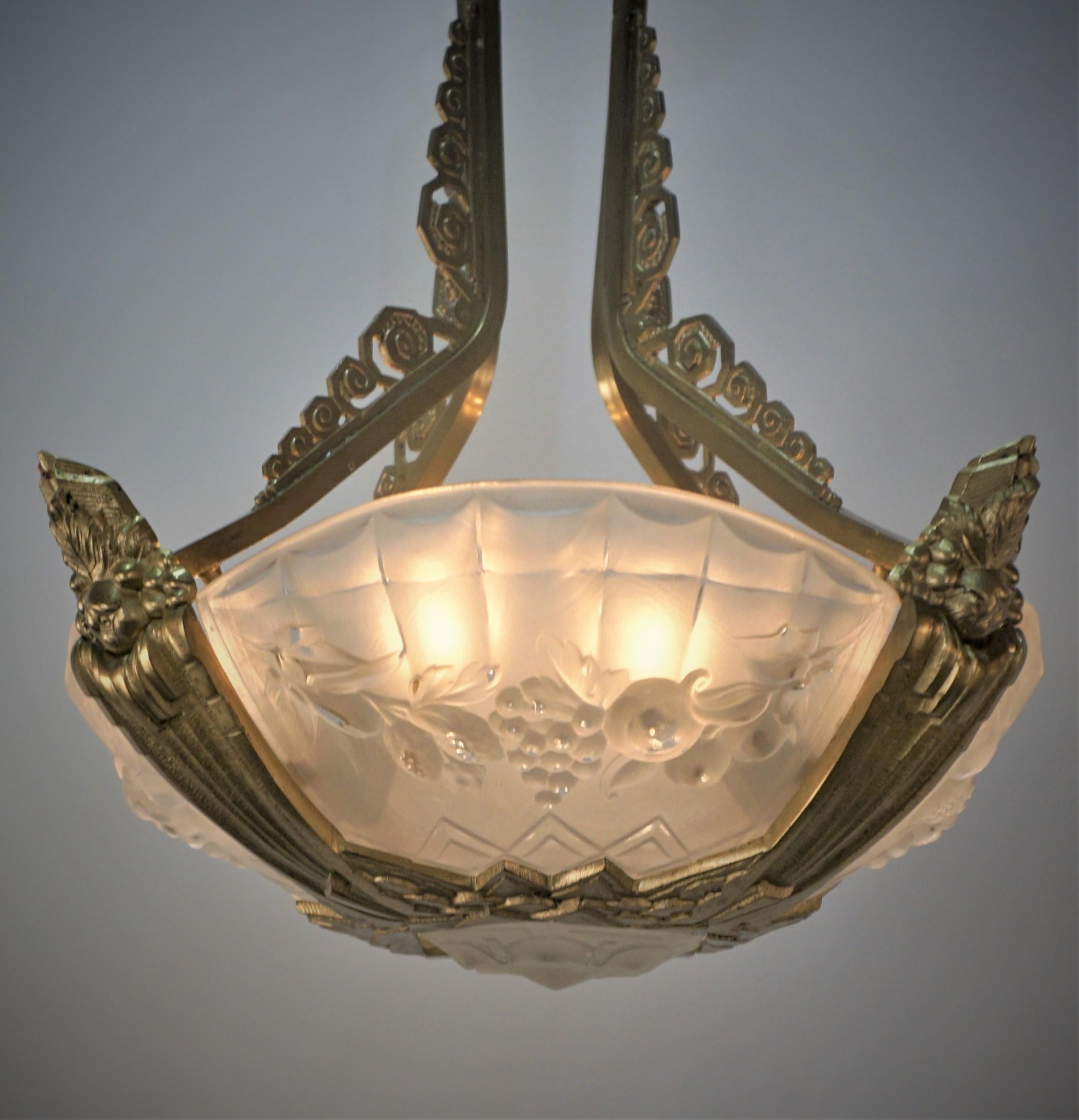 French art deco chandelier in clear frost glass and elegant bronze mounting by Pierre Gilles.
Eight lights 60watts max each.
Width measurement is widest point.