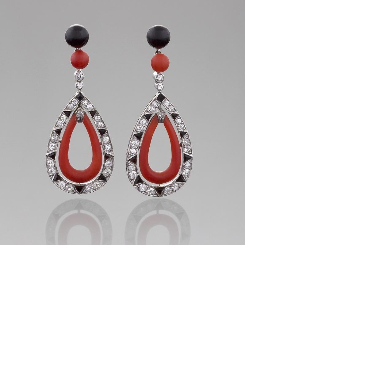 A pair of French Art Deco platinum earrings with diamonds, red coral and onyx. The earring tops have black onyx and coral beads that suspend pear shape drops with 46 old European-cut diamonds with an approximate total weight of 1.00 carat