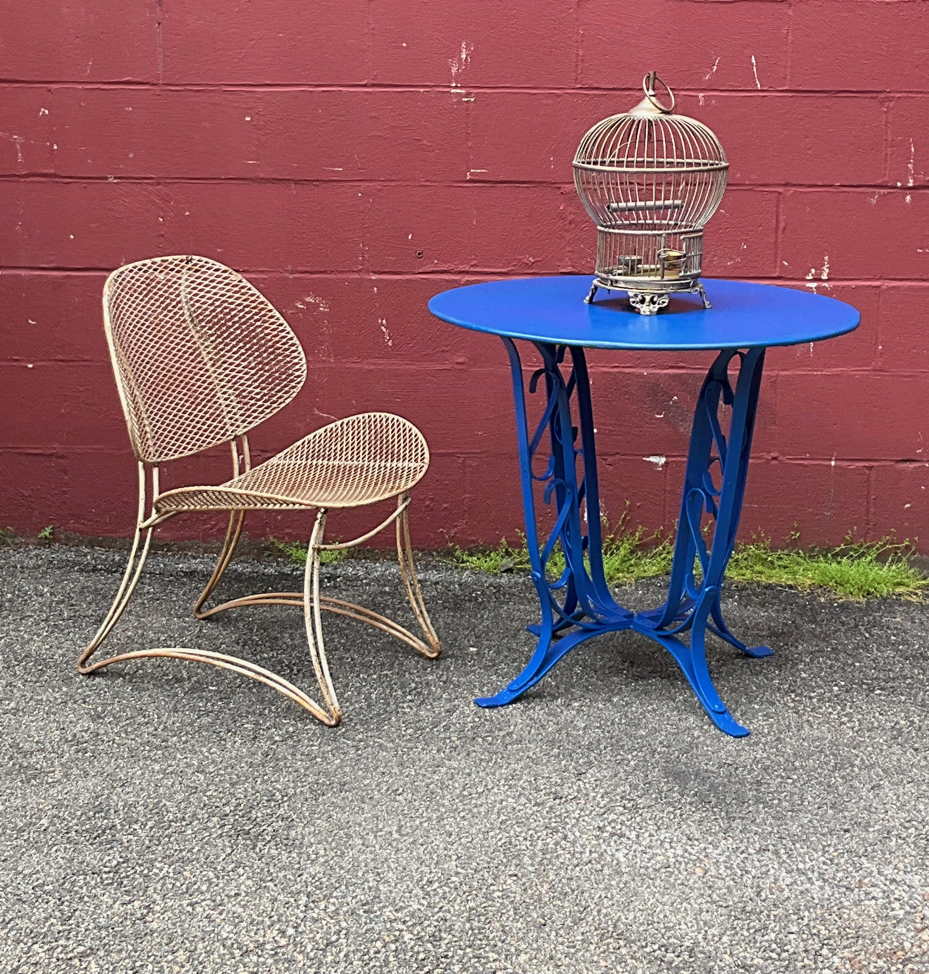 Here is a classic French garden table made in the 1920s. This table has been recently repainted in a brilliant blue rust resistant finish and is ready to be placed outside. The metal top has an opening to hold an umbrella (parasol) to give you