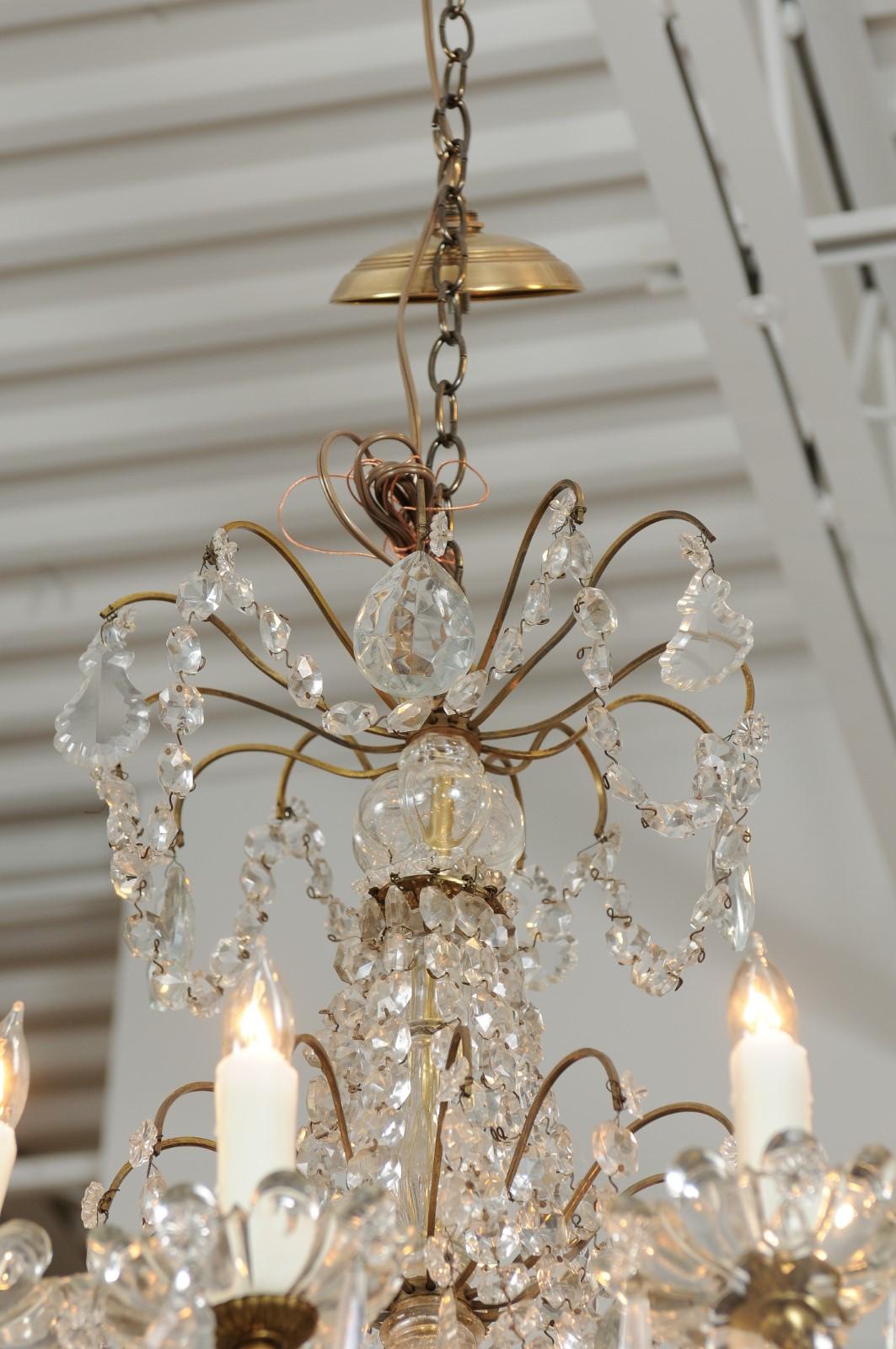 French 1920s Brass and Crystal Twelve-Light Chandelier with Scrolled Arms In Good Condition In Atlanta, GA