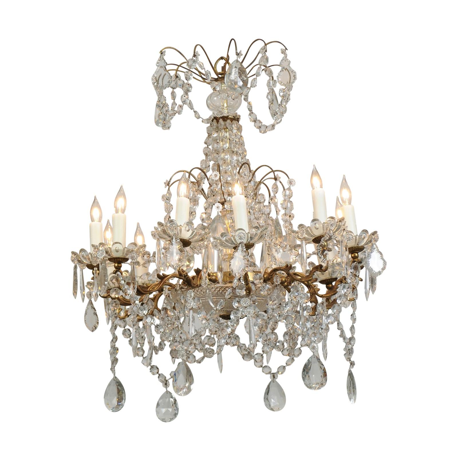 French 1920s Brass and Crystal Twelve-Light Chandelier with Scrolled Arms