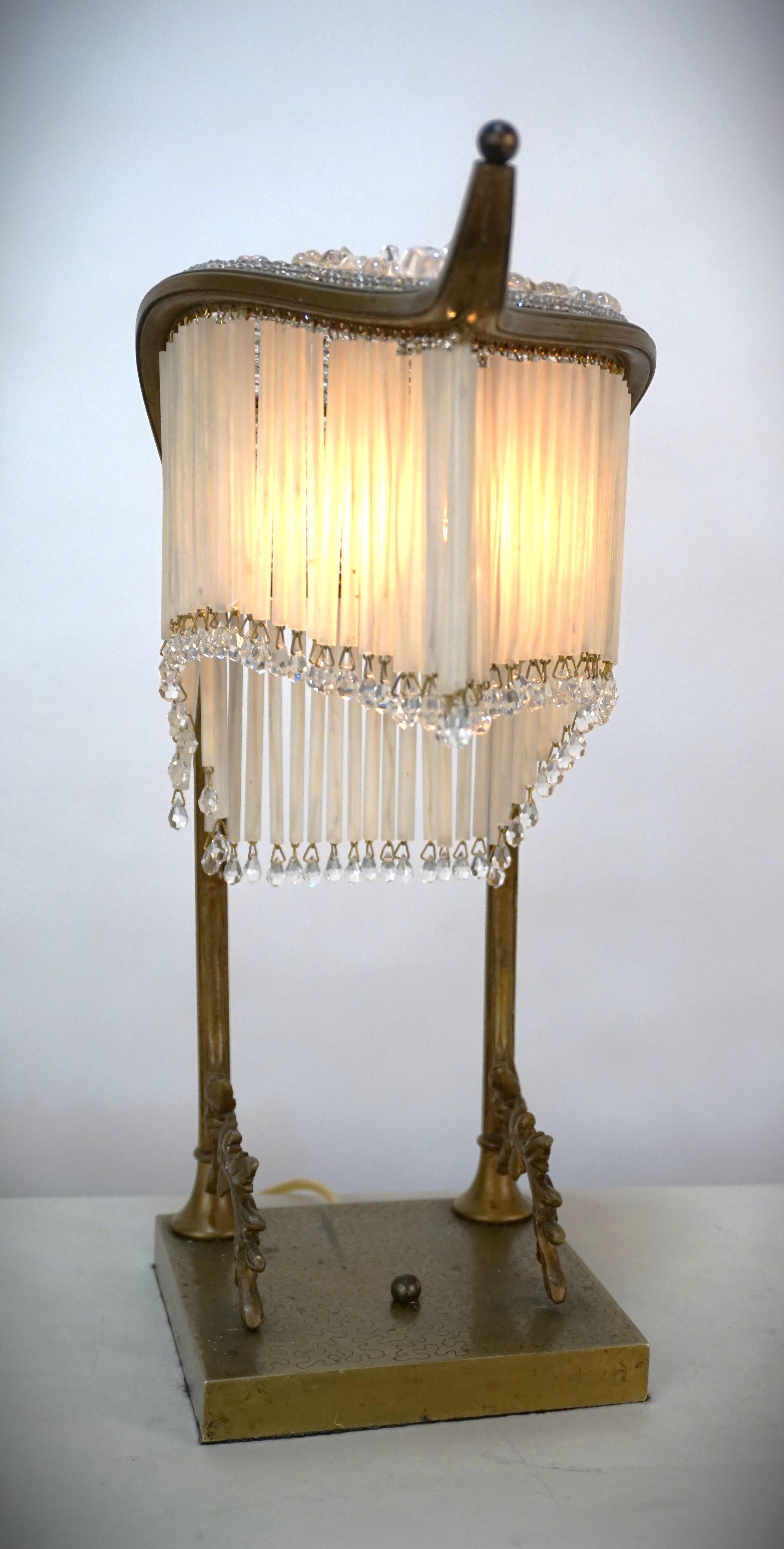 Bronze base covered with crystal beads and rosette at top and glass rods Table lamp.
New wiring.