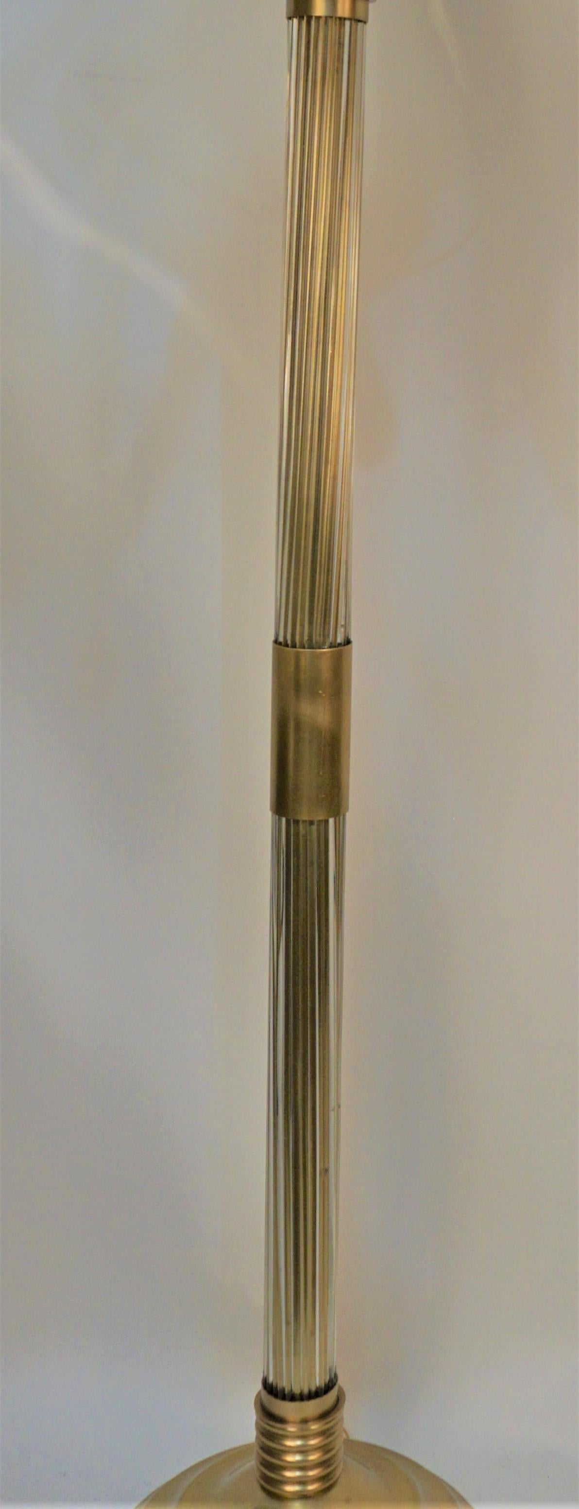 Lampadaire en bronze avec deux séries de tiges en verre transparent comme colonne centrale et quatre verres transparents étendus à partir de l'abat-jour torchère réflecteur vertical.
Quatre lampes, 100 watts max par lampe. 