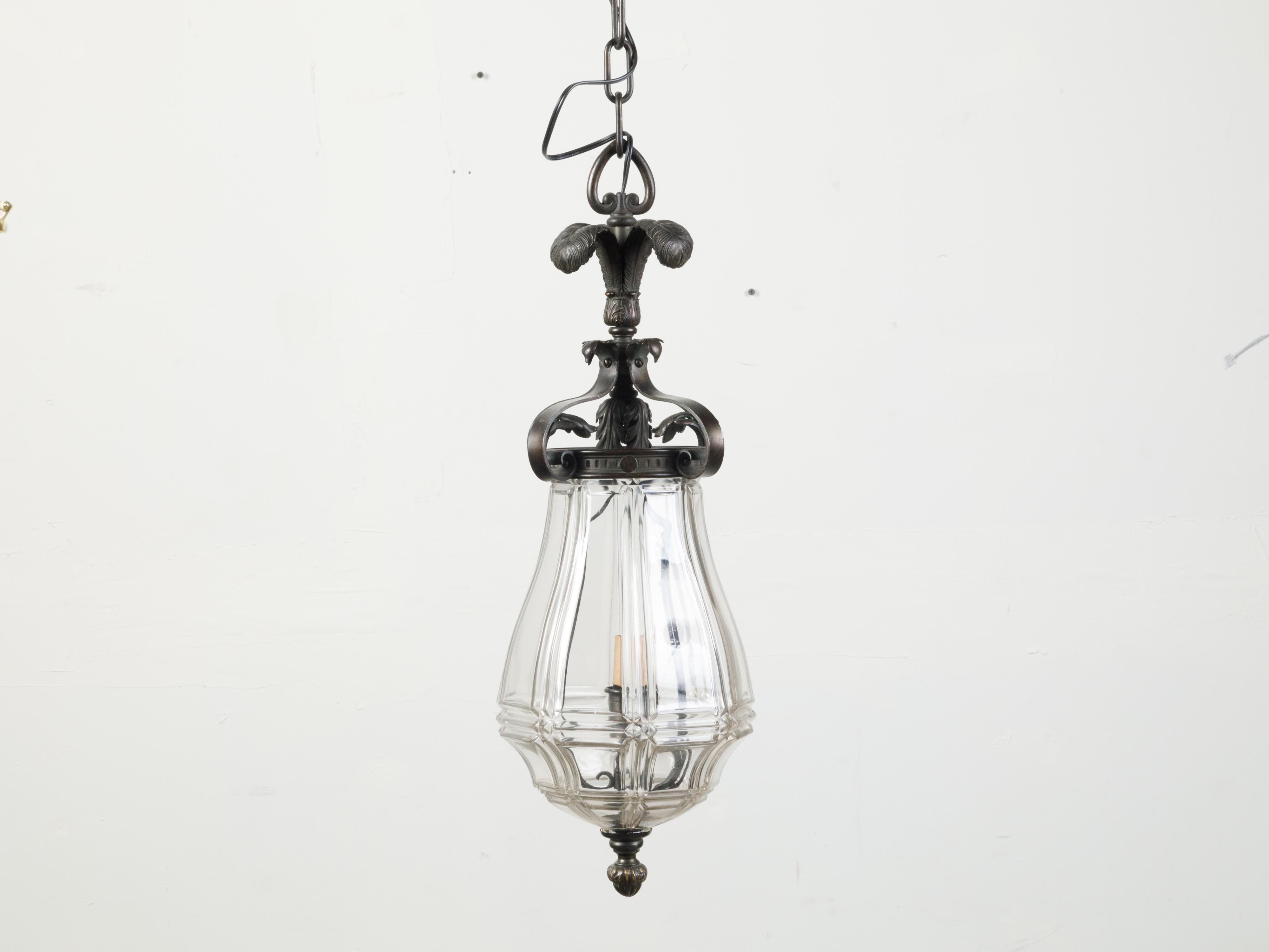 A French bronze and glass lantern from the early 20th century, with feathers and acanthus leaf motifs. Created in France during the first quarter of the 20th century, this lantern features three bronze feathers connected to graceful scrolls