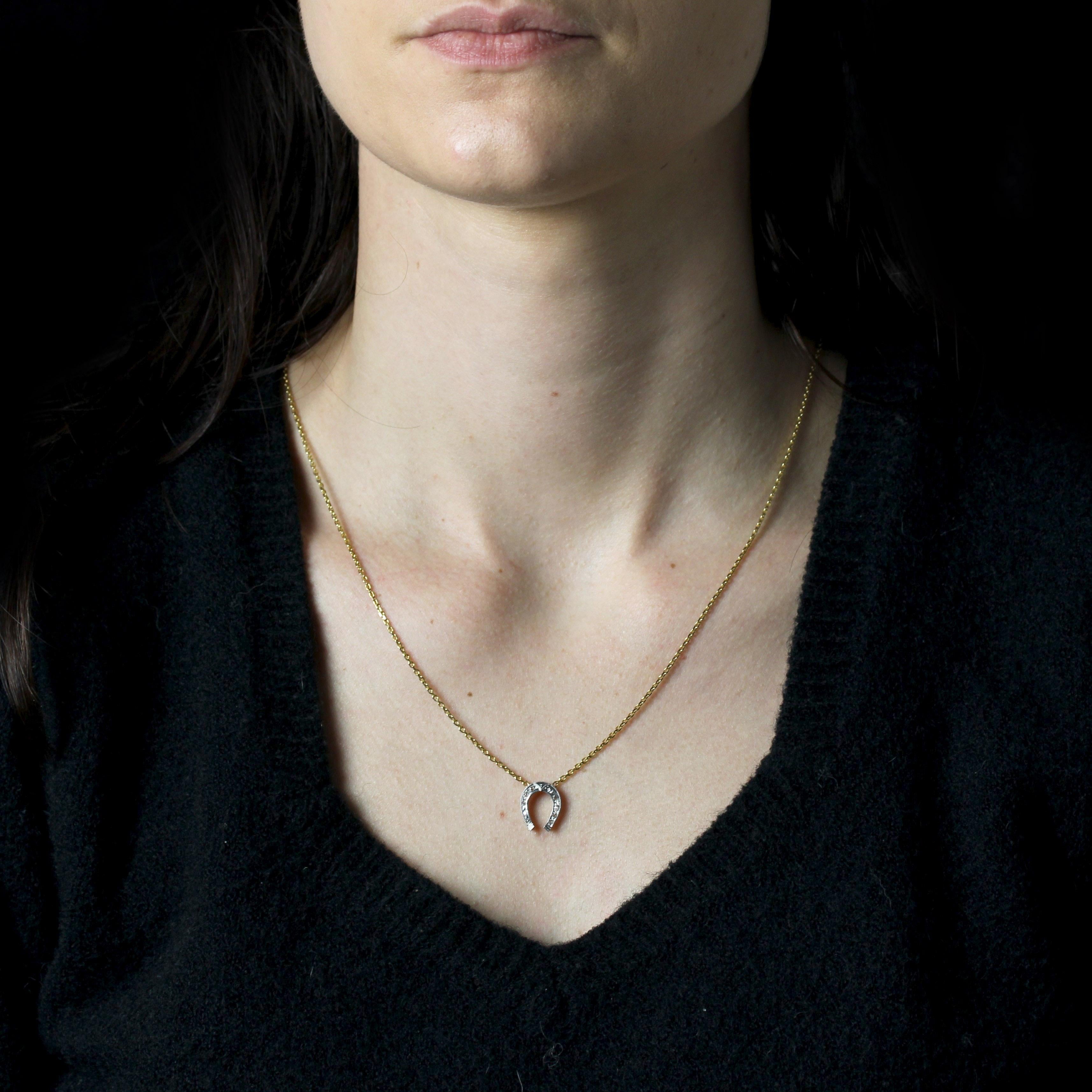 Halskette aus 18 Karat Gelbgold, Adlerkopfpunze und Platin.
Diese feminine antike Halskette zeichnet sich durch eine feine, gefeilte 
 Sträflingskette, die auf der Vorderseite ein fein ziseliertes Hufeisenmotiv trägt, das mit Diamanten im