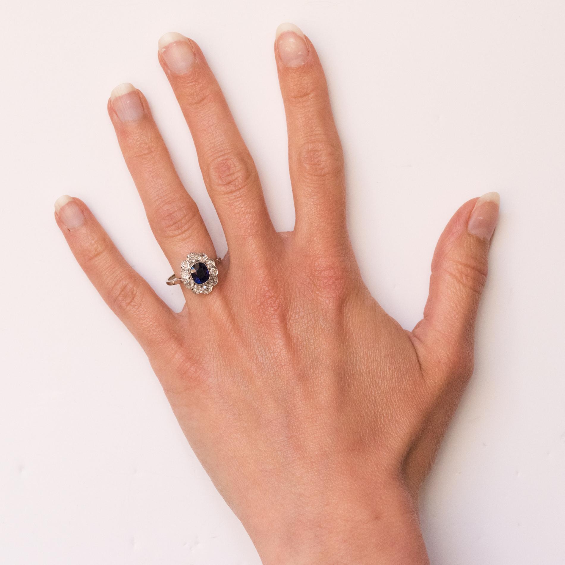 Ring in platinum.
Adorable antique ring, it is millegrains closed set in the center of a cushion sapphire of a beautiful and intense deep blue, in an entourage of antique brilliant- cut diamonds. The basket is openworked with small light and airy