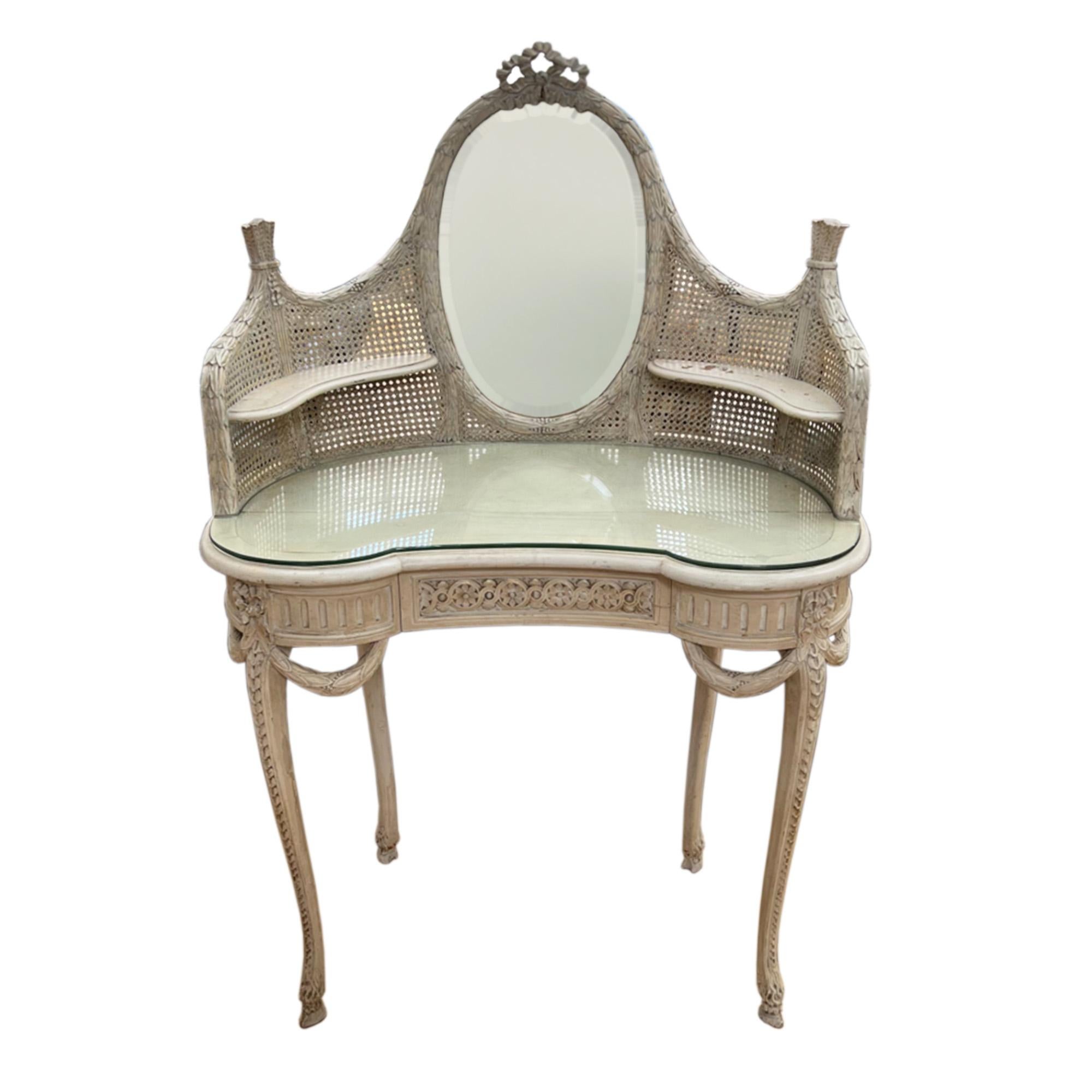 From 1920s France this Rococo styled set is a very decorative white painted kidney bean shaped dressing table and chair. 

The dressing table has a raised back, with a mirror set into the caned panelling as well and a useful removable glass