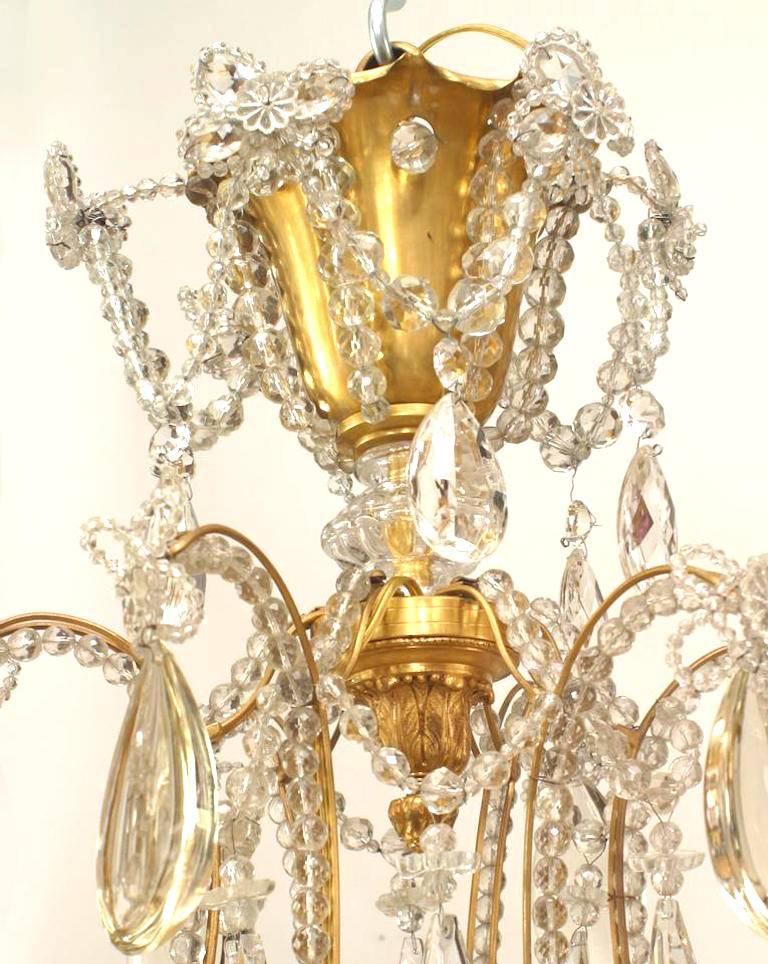 French (1920's) gilt metal chandelier with 2 tier 12 beaded crystal scroll design arms and various hanging crystal Baccarat pendants & crystal finial on bottom and center. (att: BAGUES)
