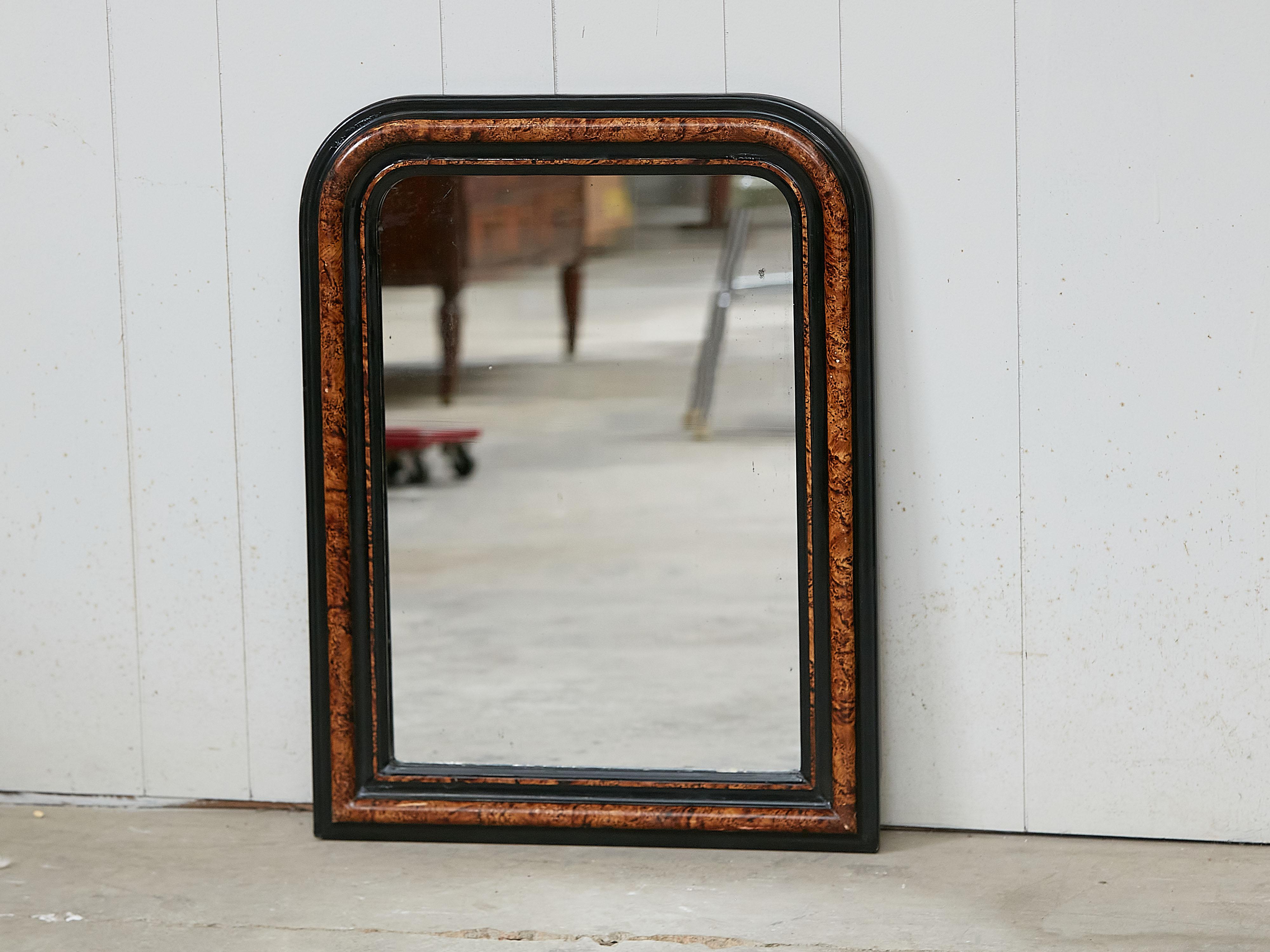 Un miroir en bois de style Louis-Philippe français du début du 20e siècle, avec un cadre peint de style tortue, avec des accents bruns et noirs. Créé en France au tournant du siècle, qui a vu la transition entre le 19e et le 20e siècle, ce miroir en