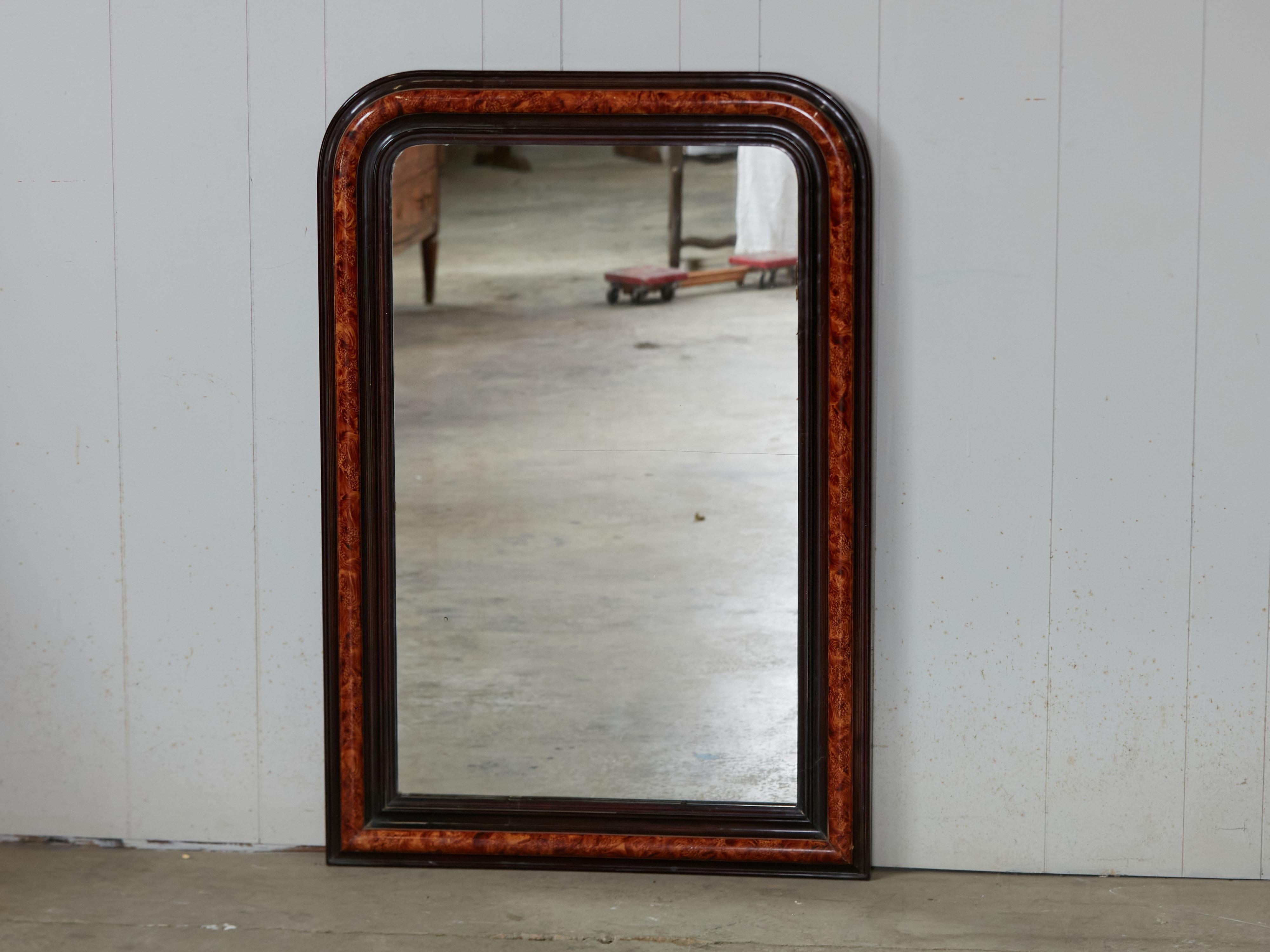 A French Louis-Philippe style wooden mirror from the early 20th century, with tortoise style painted frame. Created in France during the first quarter of the 20th century, this wooden mirror captures our attention with its Louis-Philippe silhouette