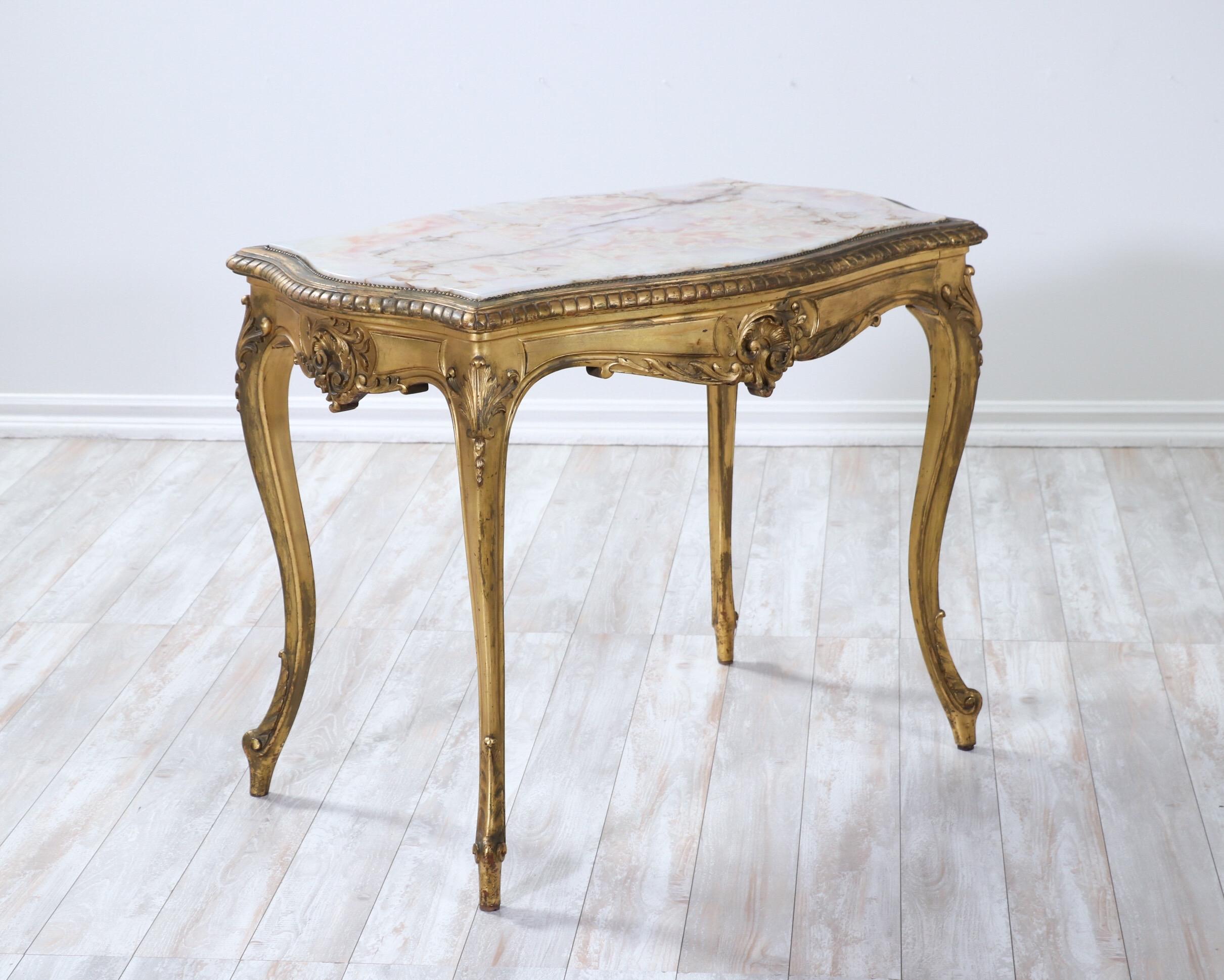 Beautiful, French 1920s giltwood and onyx-marble salon table in the Louis XV style.

Delicate carvings are featured in this “very French” salon or side table including a rocaille-themed apron and cabriole legs. The naturally aged gilt finish