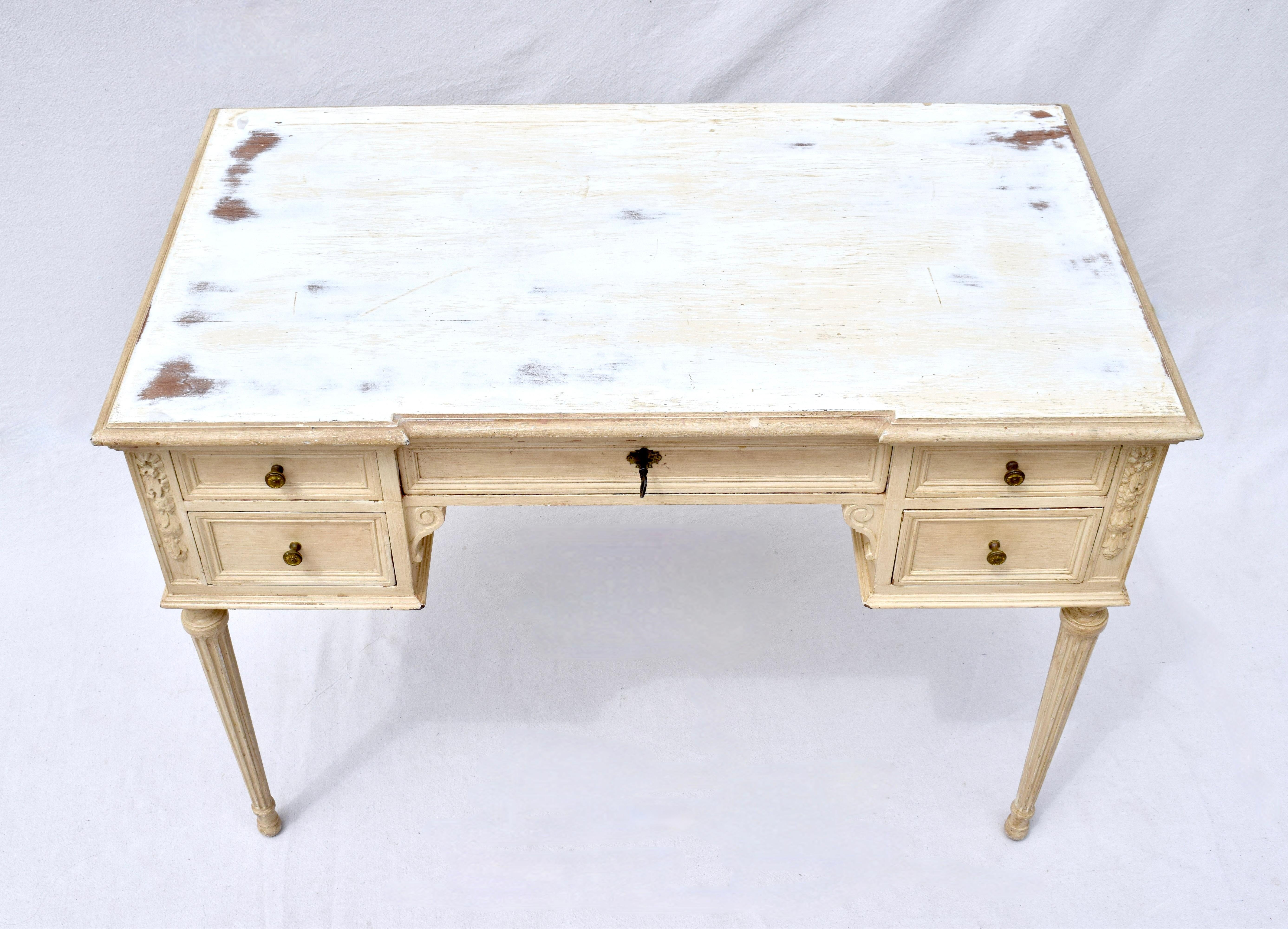 Early 20th century painted desk Louis XVI style with a center drawer including working lock & key and two drawers on each side. This very solid Mahogany desk features nicely carved embellishments throughout and is of heirloom quality.