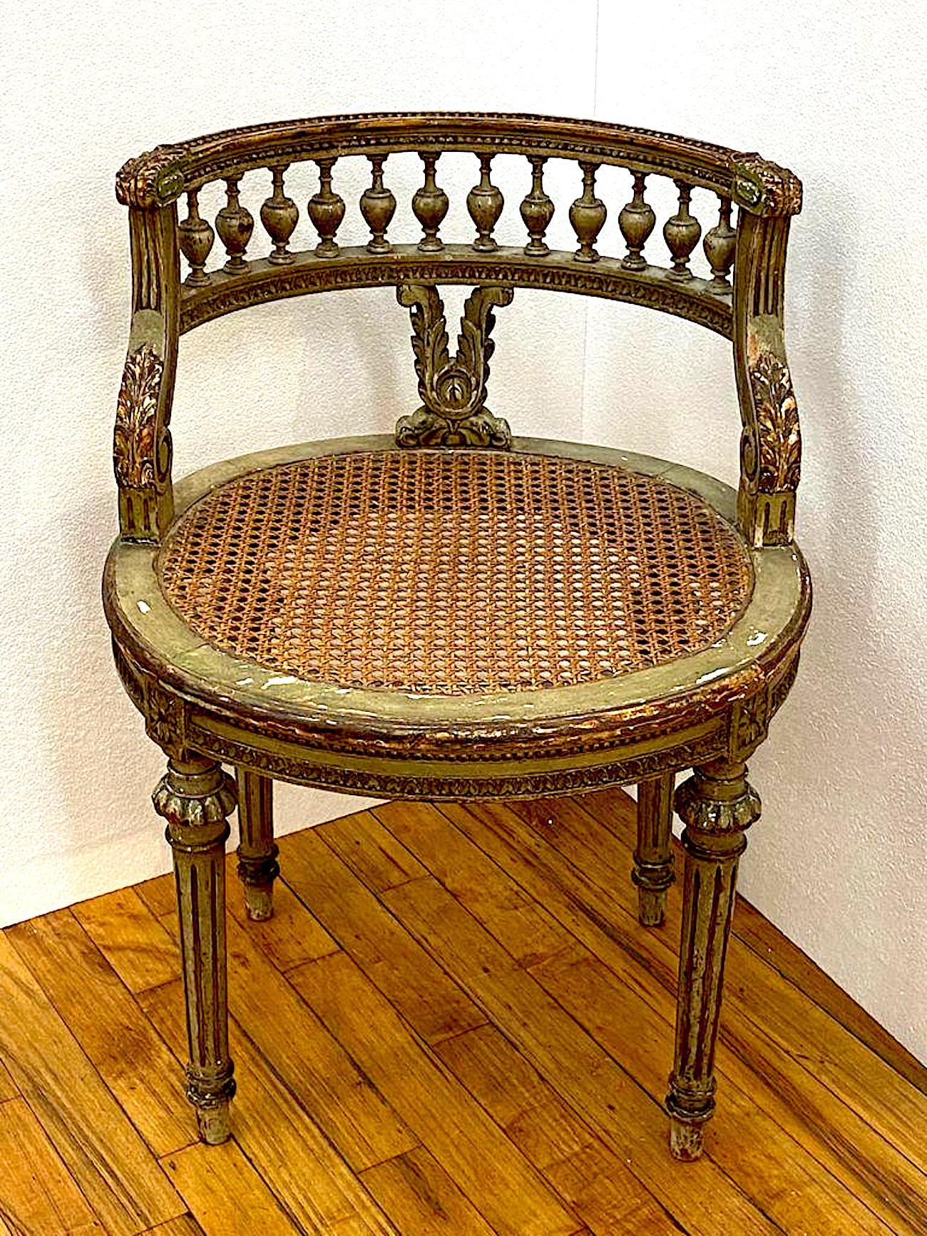 A charming Louis XVI style French vanity chair circa 1920. The chair is painted in green and parcel gilt. It has a carved foliate design V shape support for the balustrade of the chair. Additionally, there are four gilt carved foliate accents where
