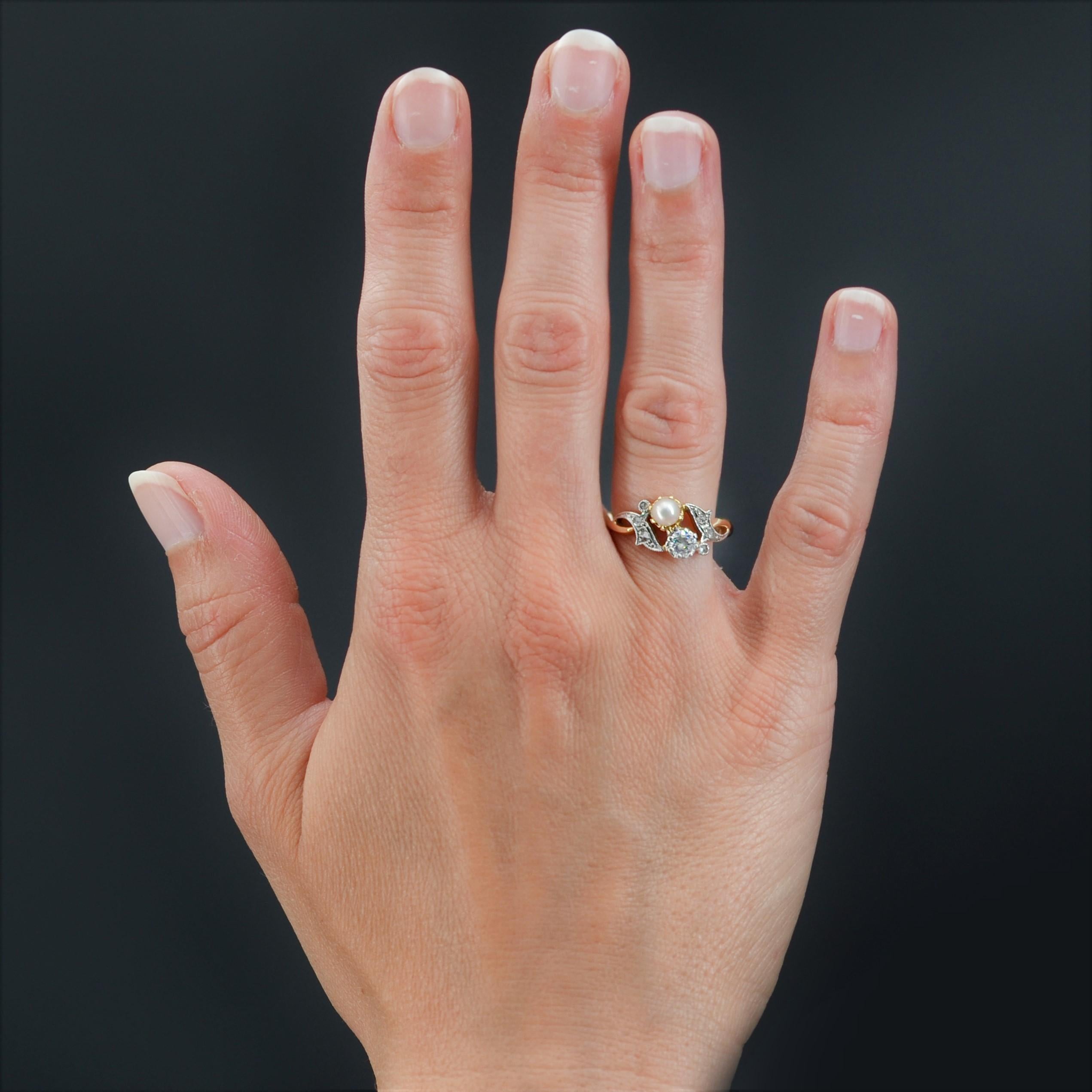 Ring in 18 karat yellow gold.
Charming antique you and me ring, it is set with claws on its top, of a brilliant- cut diamond and a small pearly white pearl. On either side, a cornucopia pattern gives the start of the ring and is set with 2x3