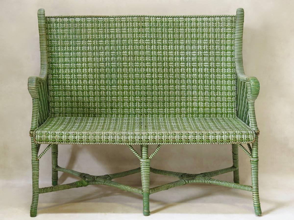 Charming early 20th century green and white wickerwork winter garden or veranda set, comprised of a two-seat settee, and two armchairs, in the style of La Maison des Bambous, and Perret & Vibert.

Dimensions provided below are for the settee. The