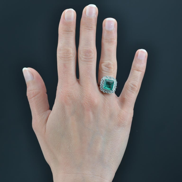 Ring in platinum. 
Sublime and feminine Art Deco ring, it is set with a rectangular- cut emerald in a surround of 8/8- cut diamonds bordered by a millegrain. The very flat setting presents an openwork basket. 
Weight of the emerald : 2.60 carats