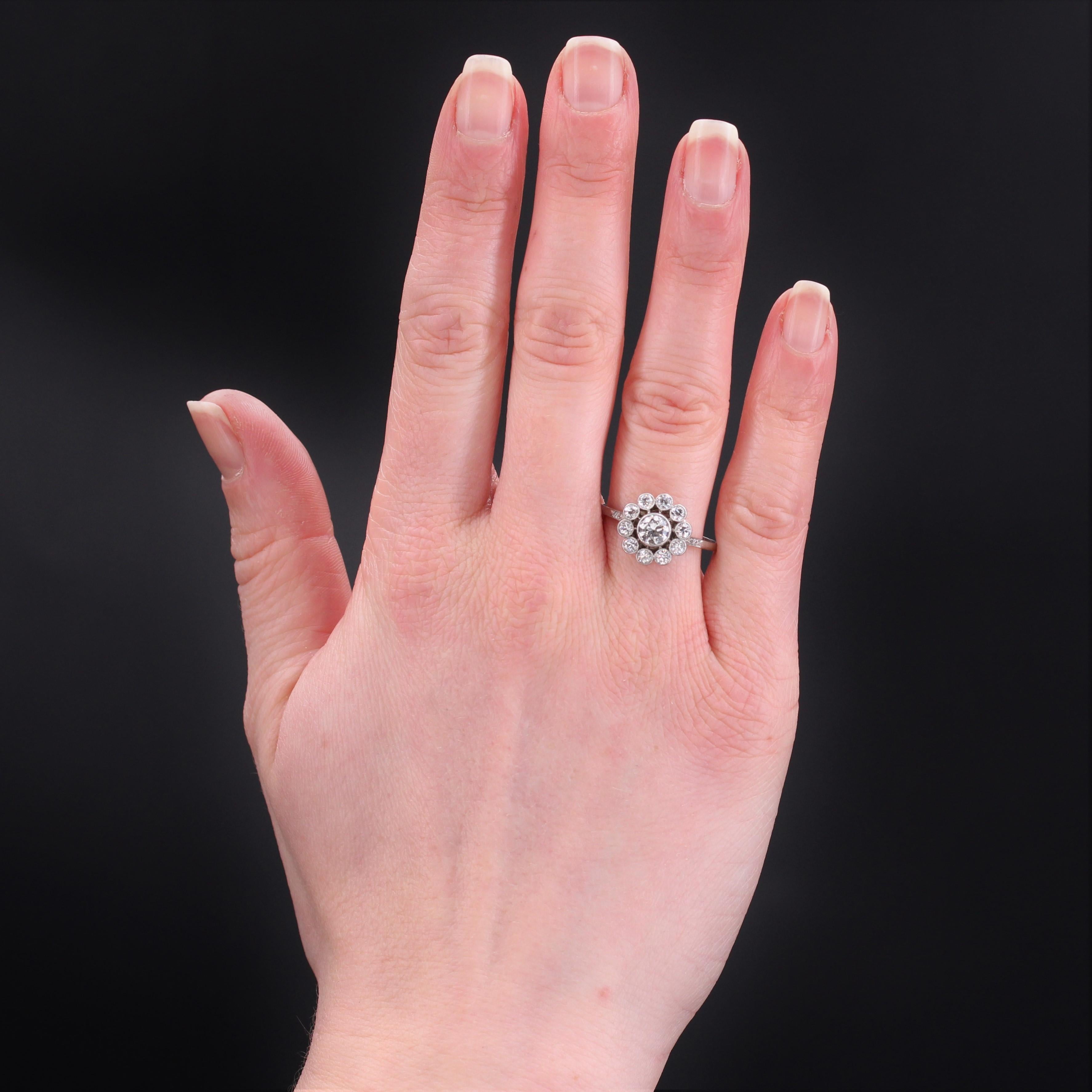 Ring aus Platin, Hundekopfpunze.
Dieser schöne Blumenring ist mit antiken Diamanten im Brillantschliff in einer geschlossenen Fassung besetzt, wobei der mittlere Diamant größer ist. Das Körbchen ist wunderschön durchbrochen und der Anfang des Rings