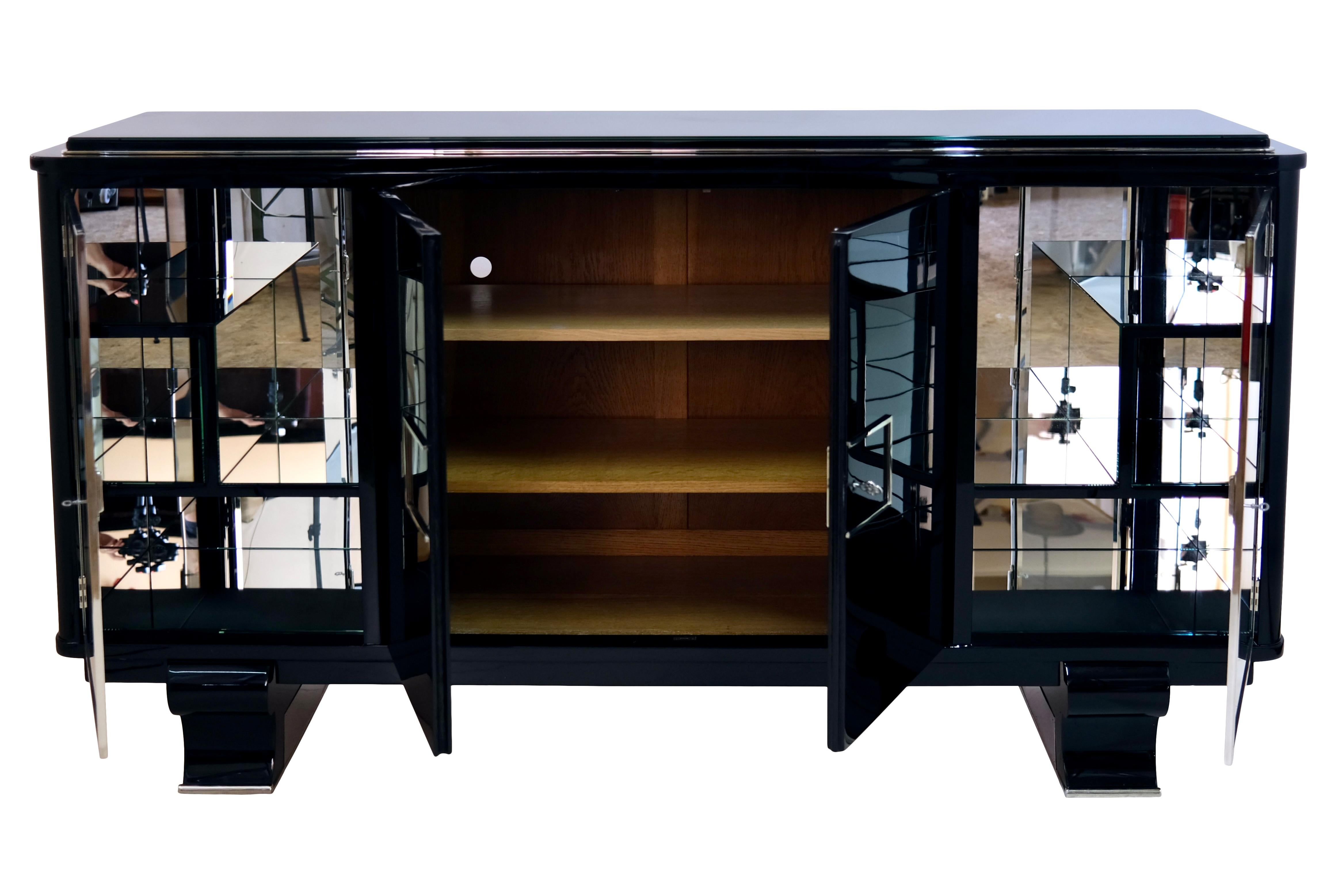 Modernist Sideboard
Piano lacquer, black high gloss
Large central compartment, two-door opening
Side, mirrored compartments behind transparent glass doors

Original Art Deco, France 1930/40s

Dimensions:
Width: 198 cm
Height: 106 cm
Depth: