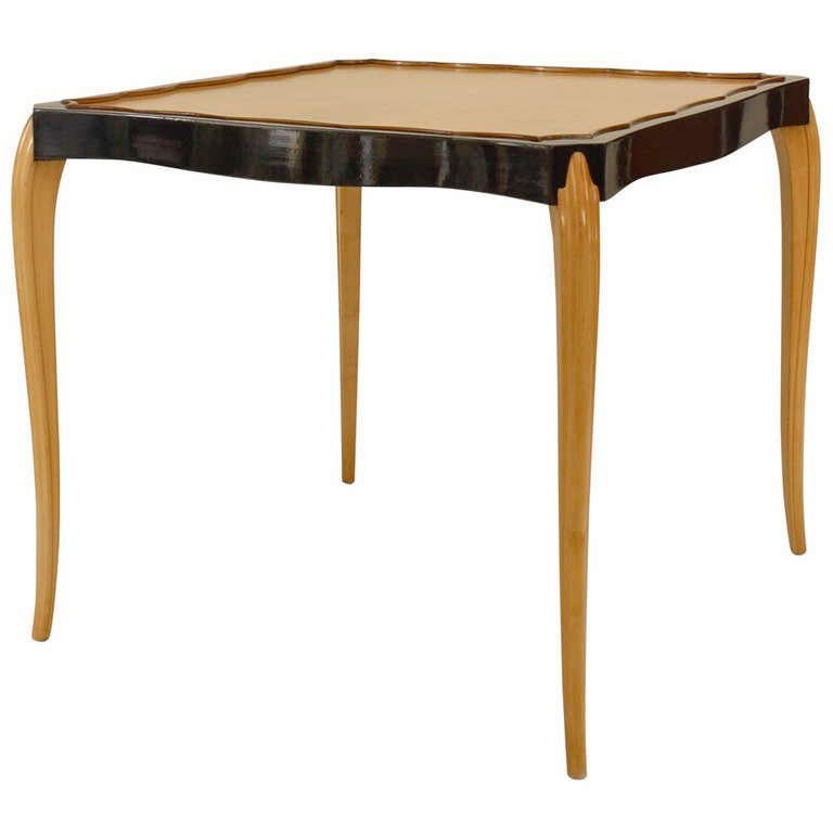 French 1930s sycamore game table with an ebonized apron and scalloped top edge and supported on slight cabriole form legs. (attributed to MAURICE DUFRENE)

