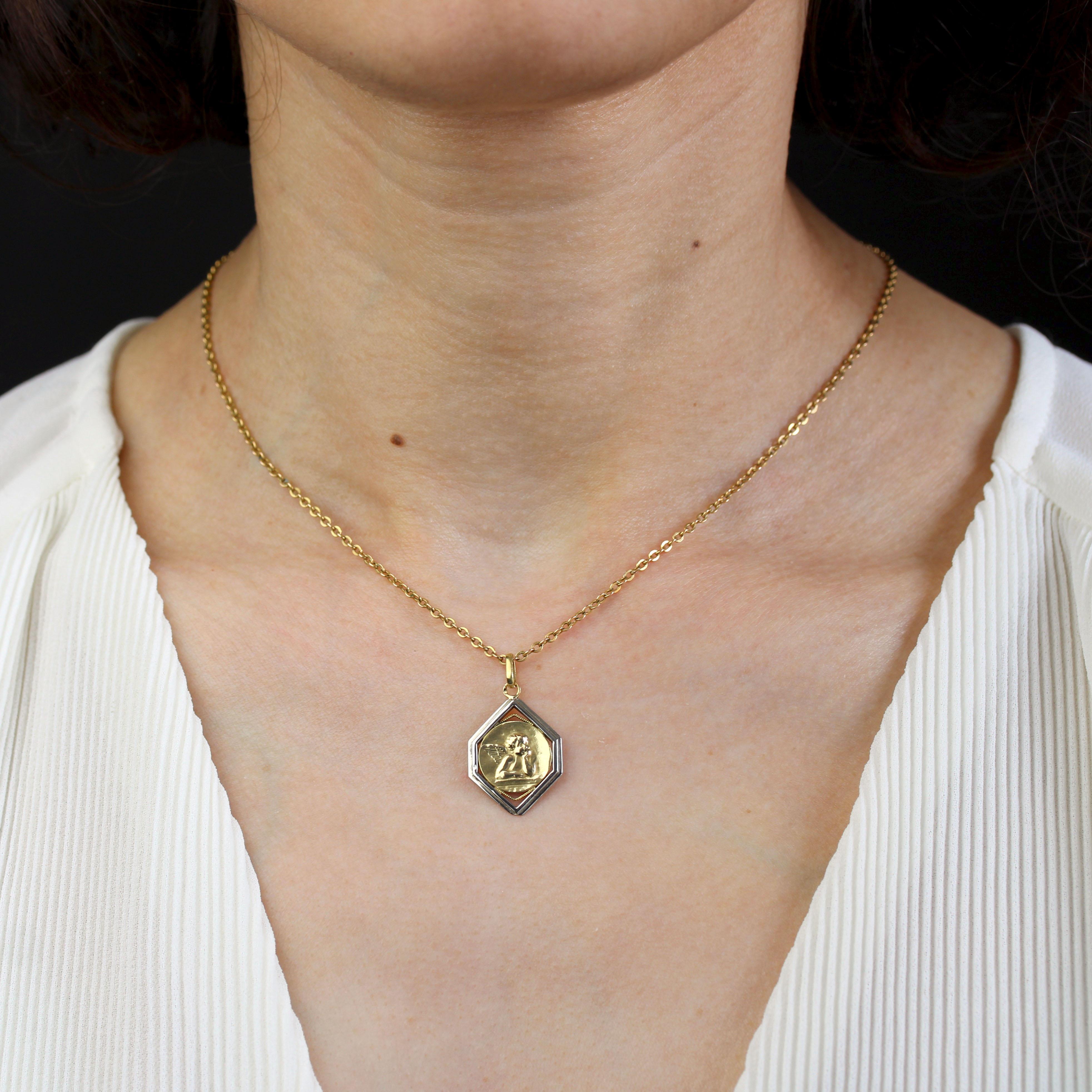 Medal in 18 karat yellow and white gold, eagle head hallmark.
Antique medal depicting an angel on a round yellow gold background, framed by a geometric white gold border with a yellow gold beaded line. The back is engraved with initials.
Pendant
