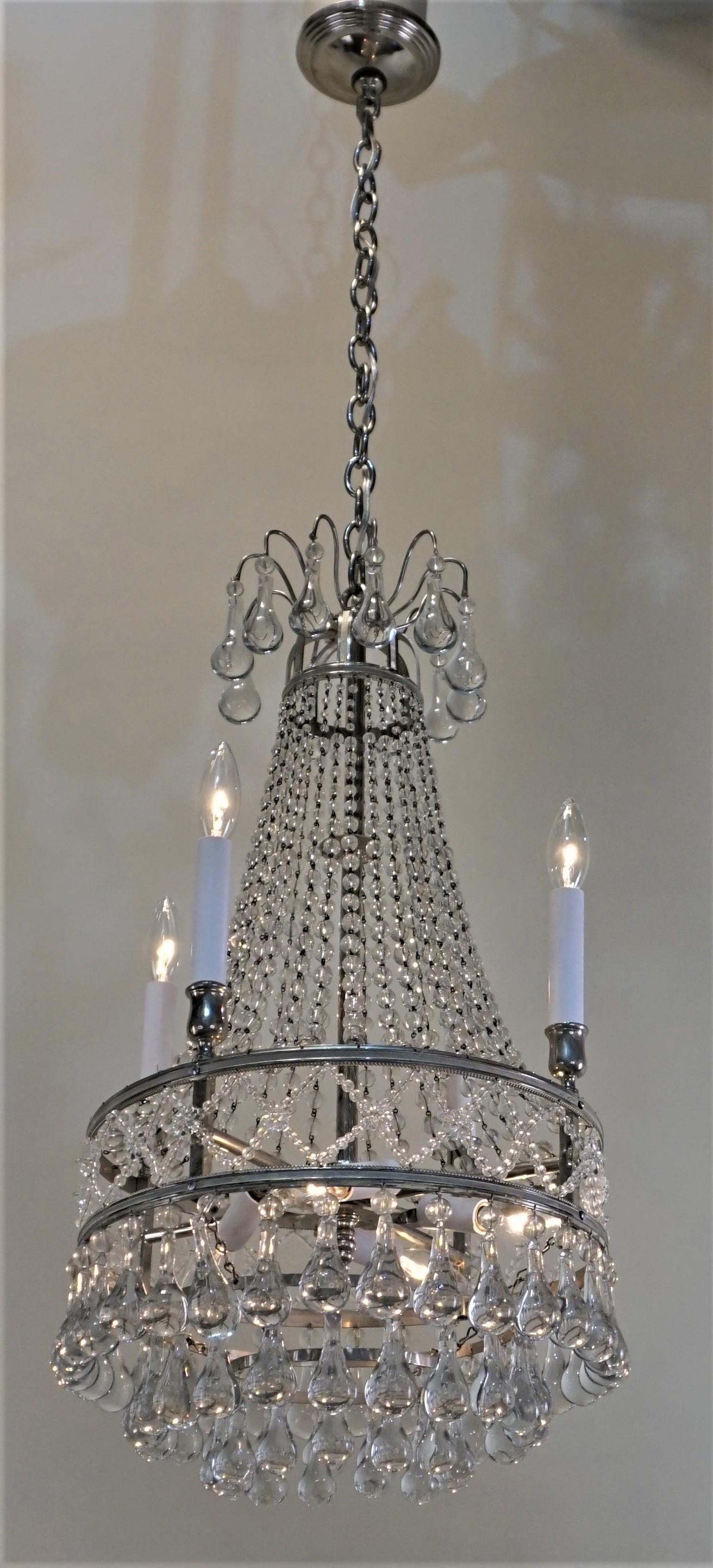 1930s Art Deco chandelier. This beautiful chandelier is crafted in France has graduated fasted crystal chain and large rain drop crystal with nickel on bronze frame.
Total of eight lights 60 watt max each.
Height can be adjusted by removing some