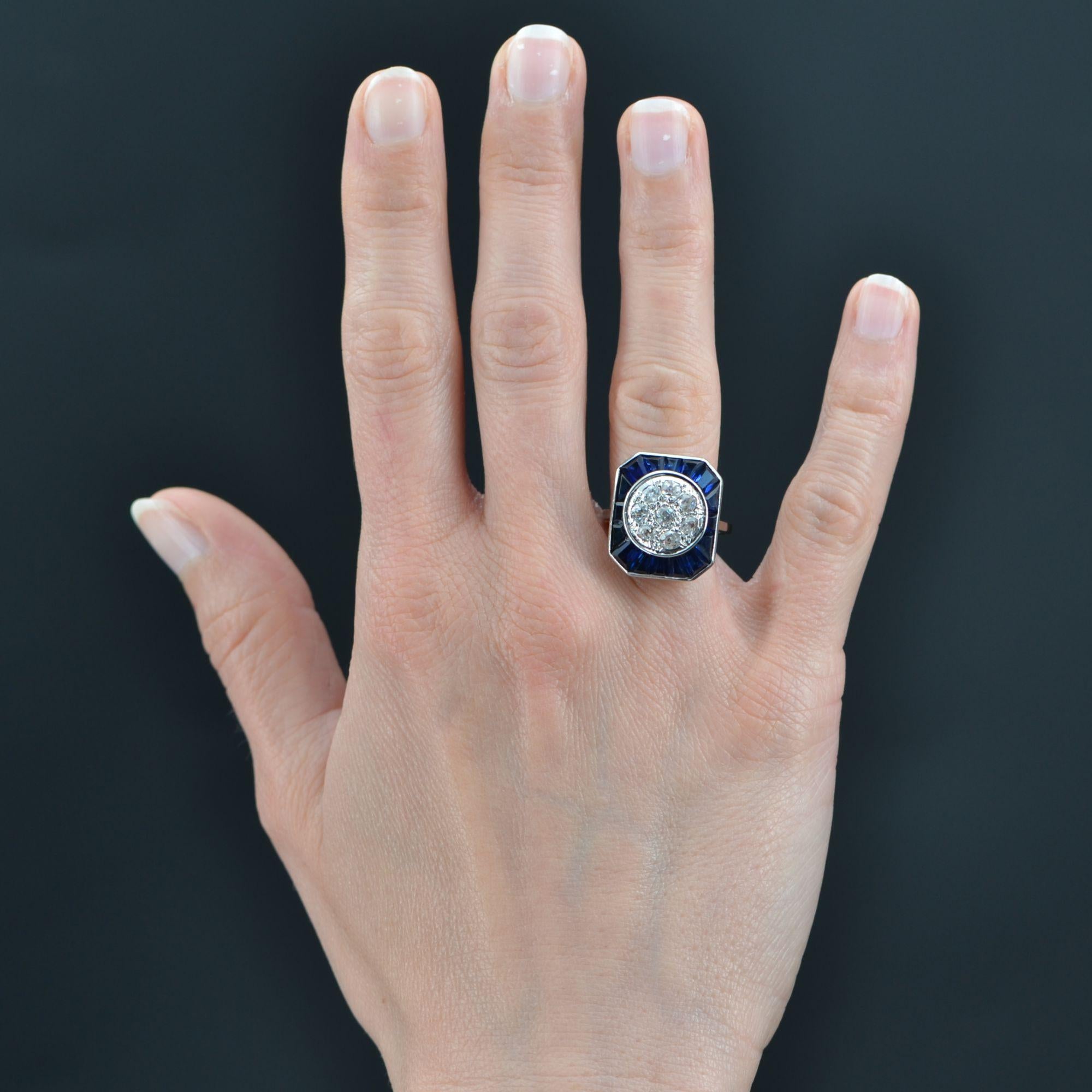 Ring in 18 karat white gold, own hallmark.
Important Art Deco ring, it presents a setting of rectangular shape with cut sides decorated with a radiant decoration of calibrated synthesis sapphires in the center of which are antique cushion-cut