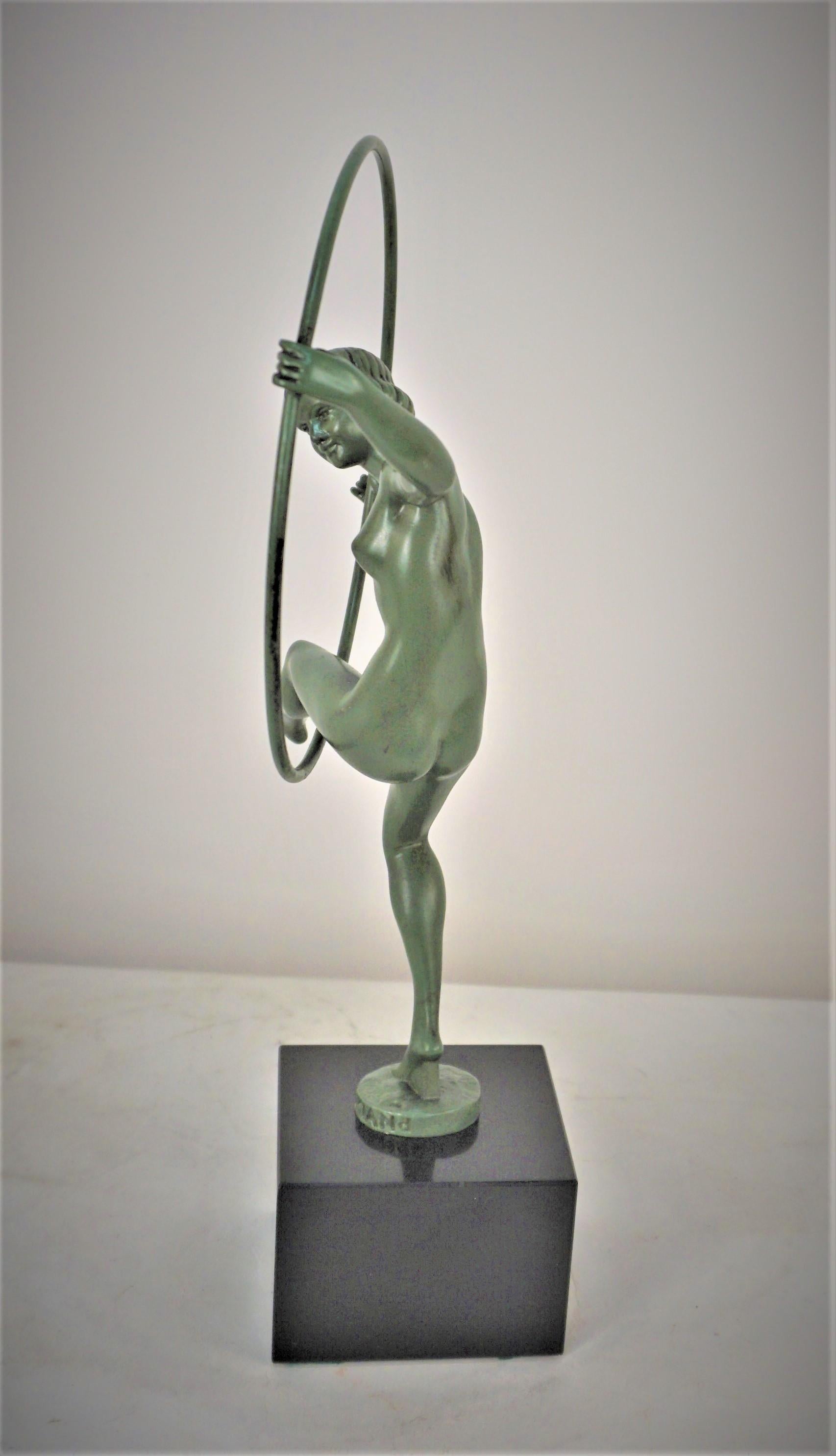 Danseuse nue Art déco avec cerceau, est signée Briand, pseudonyme de Marcel Andre Bouraine et coulée par la fonderie Max Le Verrier, en peinture à froid verte et socle en marbre noir.