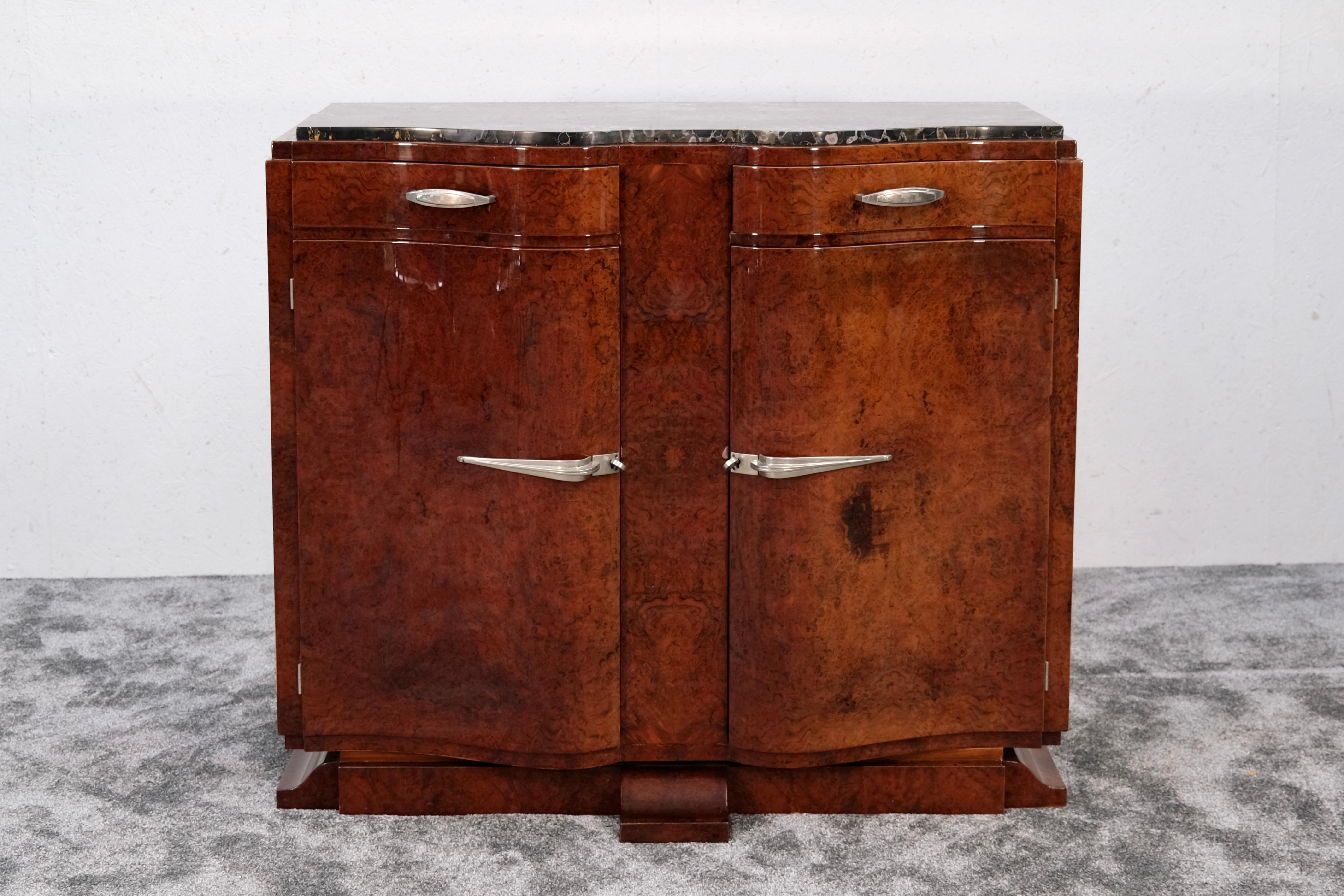 Questa squisita credenza francese Art Deco degli anni '30 è uno splendido esempio di eleganza modernista, che mette in mostra il fascino senza tempo del periodo Art Deco. Realizzato in rara radica di Amboyna, la sua ricca finitura laccata lucida fa